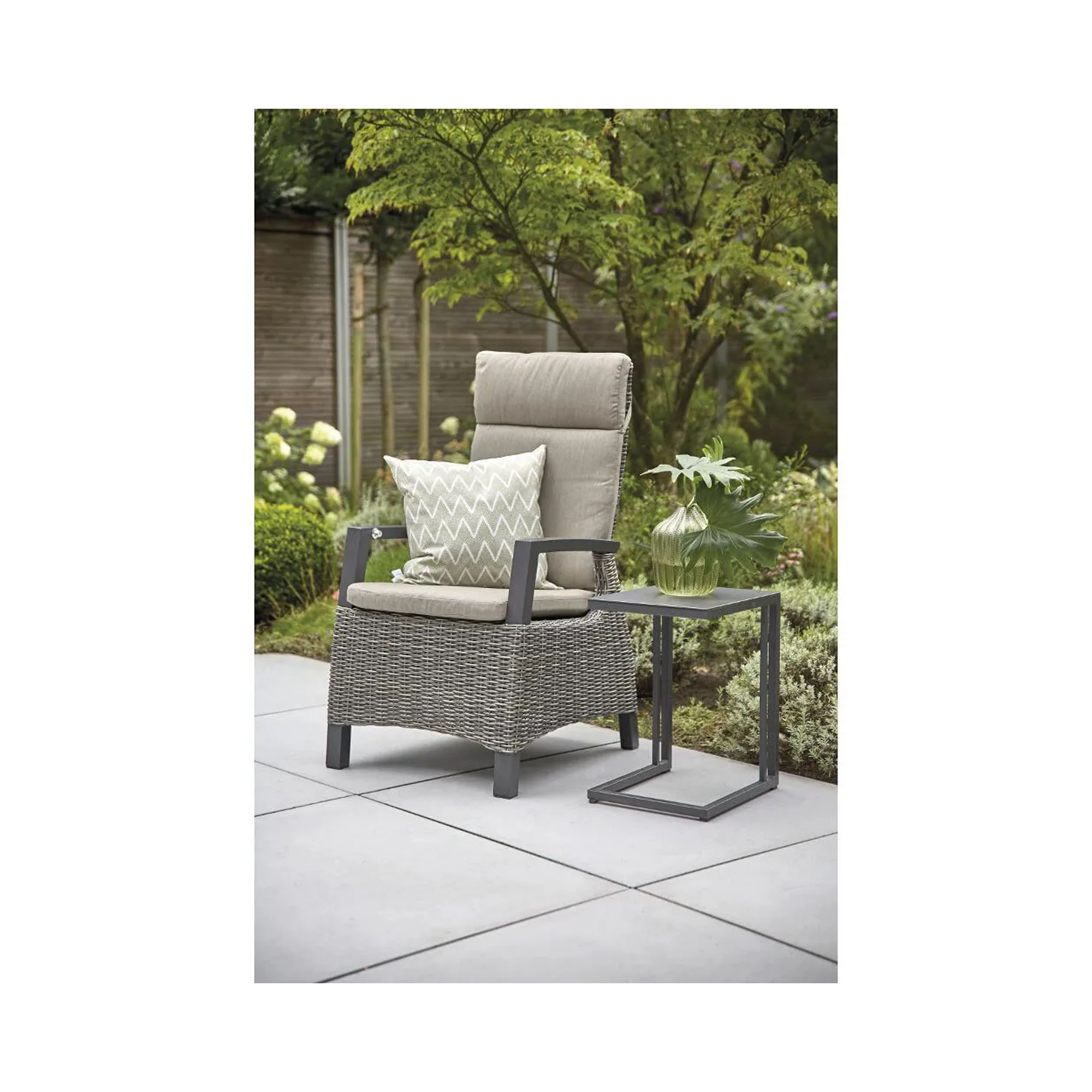 Grauer Hochlehner-Gartenstuhl mit Kissen und Beistelltisch aus Metall auf einer modernen Terrasse im Gartenambiente.