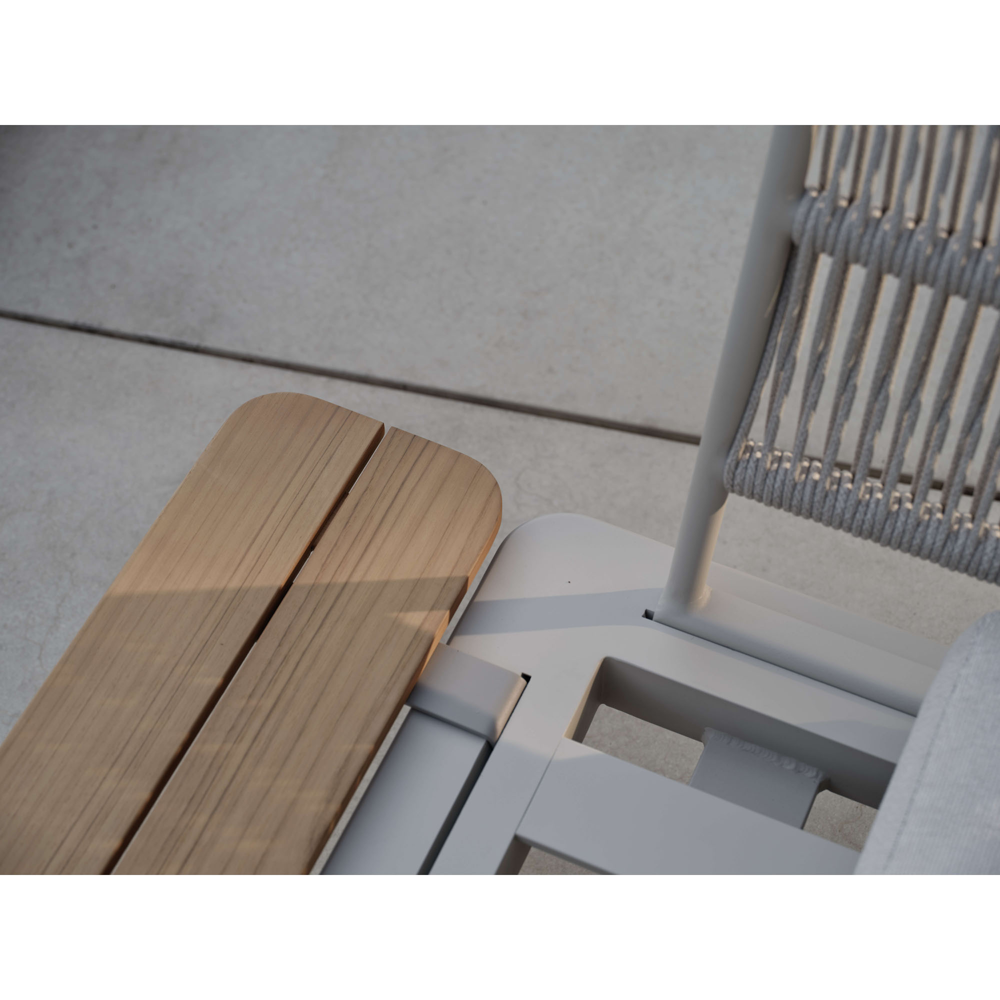 Detailaufnahme einer seitlichen Ablage aus Holzleisten neben einem Sitzmöbel mit sichtbarer Rückenstruktur