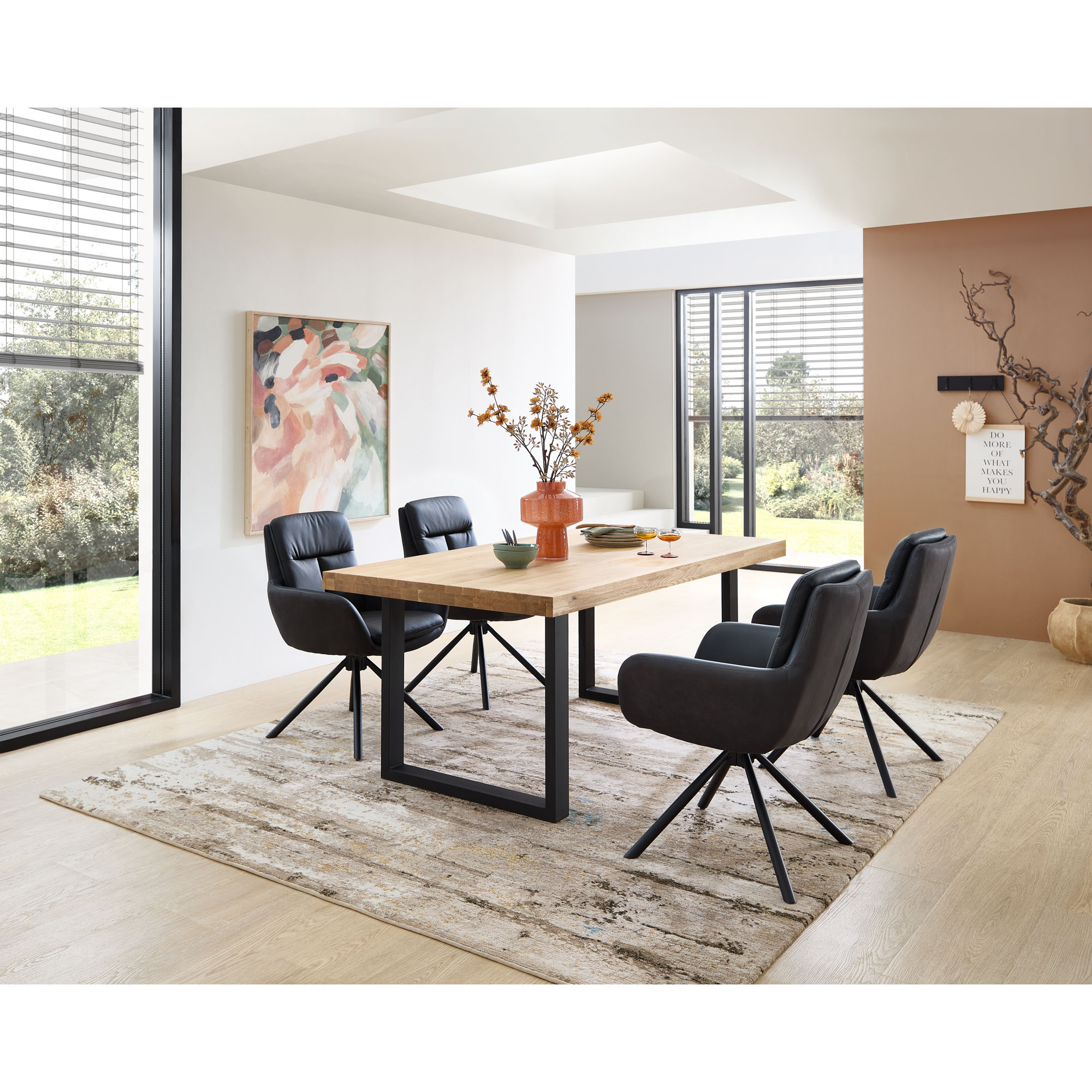 Esszimmer mit Holztisch und vier schwarzen Polsterstühlen mit Armlehnen und schwarzem Gestell
