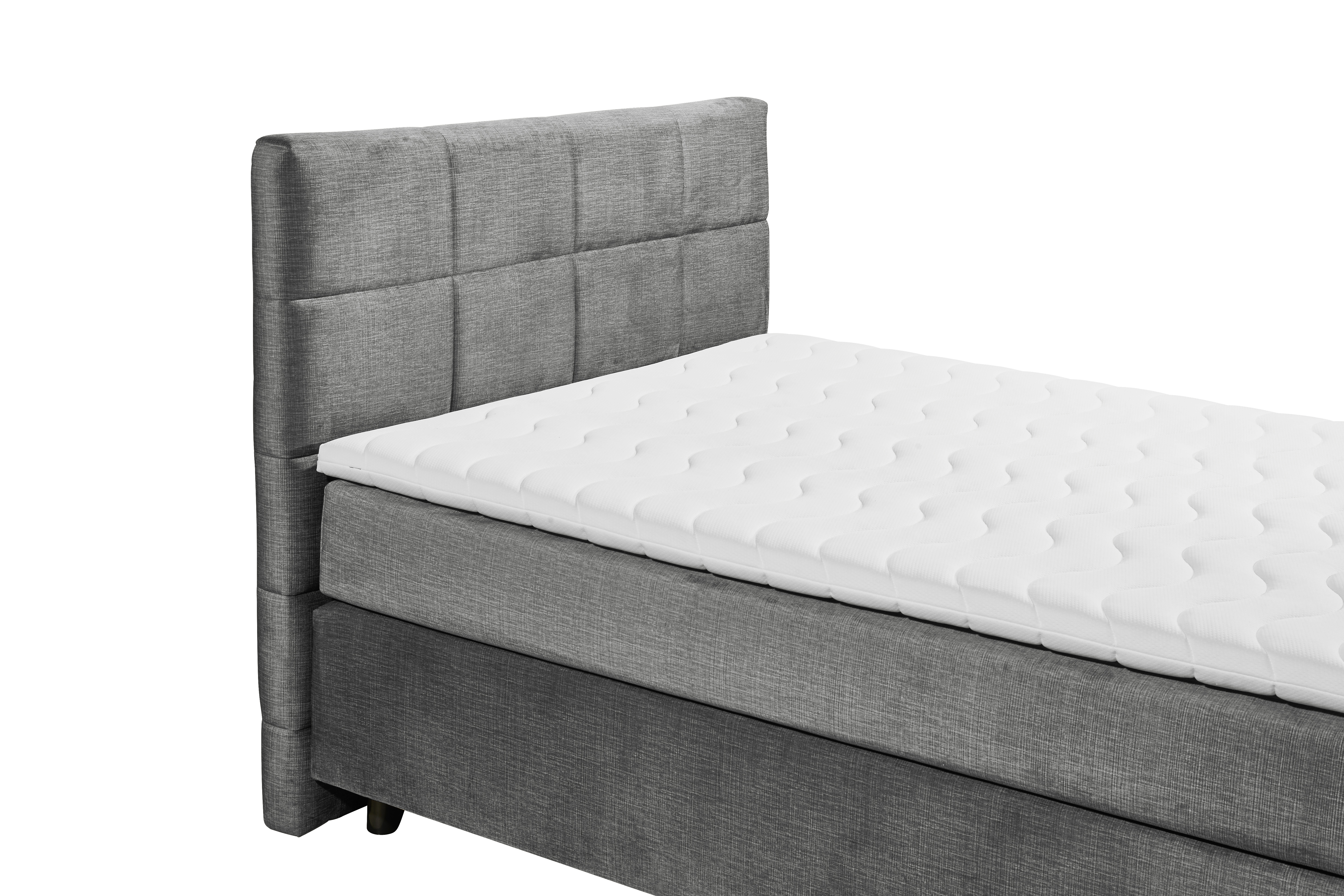 Boxspringbett „Voss 15 grey“ aus schräger Perspektive nahe am Kopfteil fotografiert, grauer Stoffbezug, Details der Matratze und des Toppers sichtbar