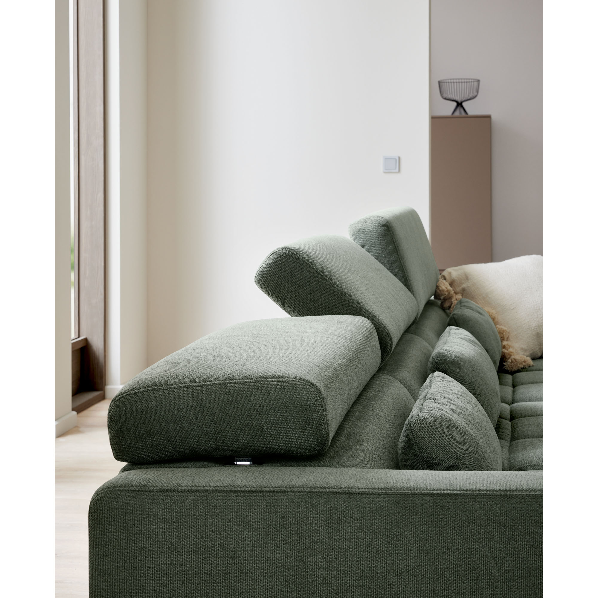 Detailaufnahme der verstellbaren Kopfstütze eines grünen Ecksofas Interliving 4303  mit Stoffbezug