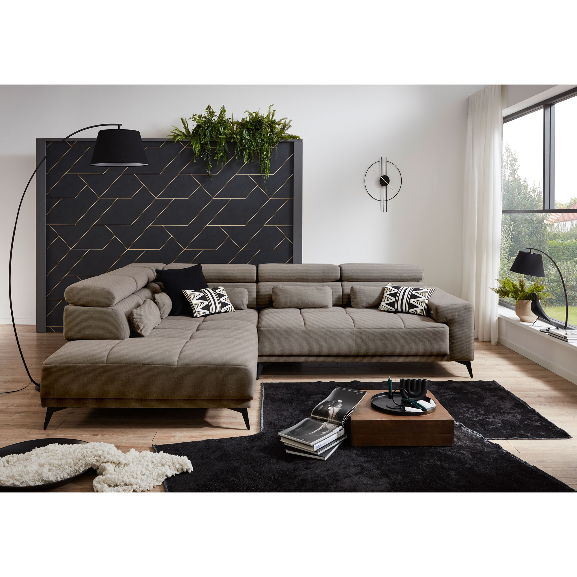 Hellgraues Ecksofa mit Ottomane links, verstellbaren Kopfstützen und Dekokissen in einem modern eingerichteten Wohnzimmer