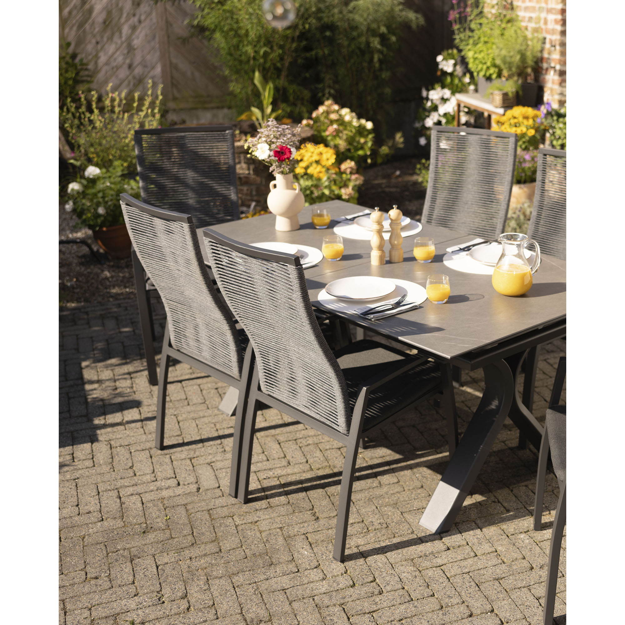 Mehrere Gartenstühle an einem gedeckten Tisch im Außenbereich