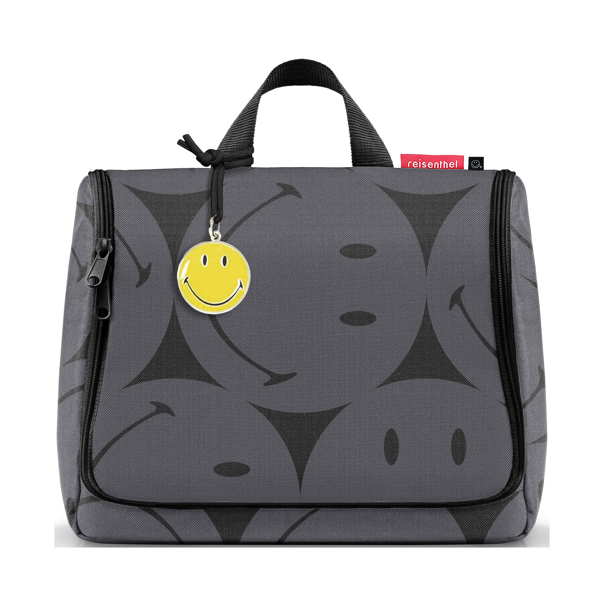 Kulturbeutel von Reisenthel, Modell Toiletbag XL, in Grau mit großflächigem Smiley-Muster, frontal geschlossen mit Tragegriff und Smiley-Anhänger.