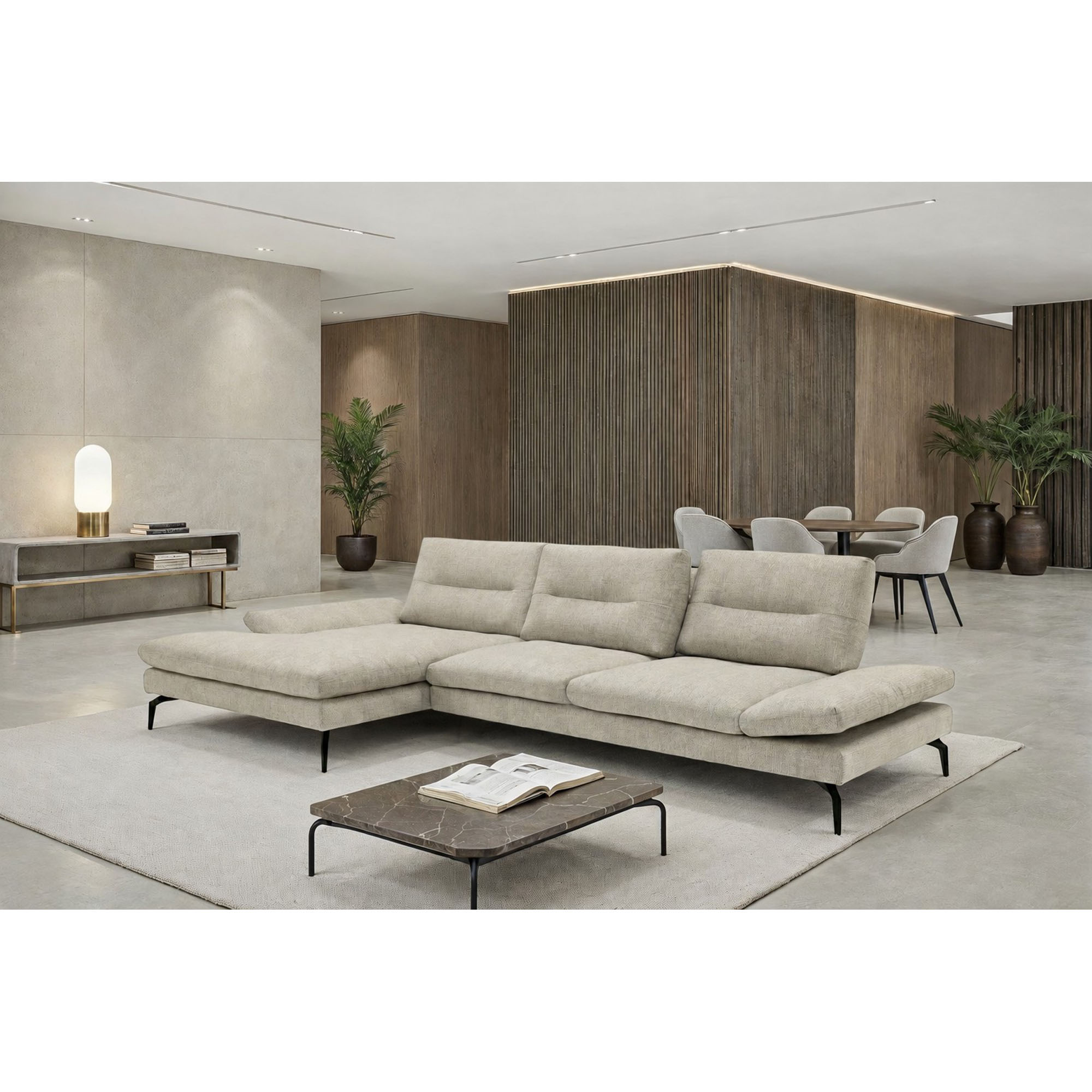 Beiges Ecksofa mit schwarzem Metallgestell und Ottomane links, inszeniert in einem modernen Wohnraum mit Couchtisch und Essbereich.
