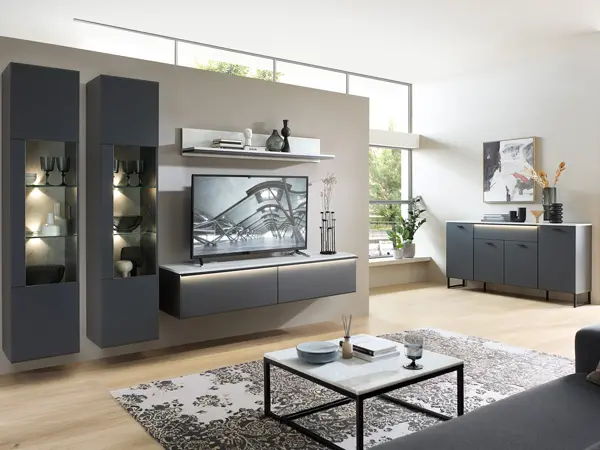 Modern eingerichtetes Wohnzimmer mit schwarzer Wohnwand, beleuchteten Vitrinen, TV Lowboard, Wandboard und Sideboard