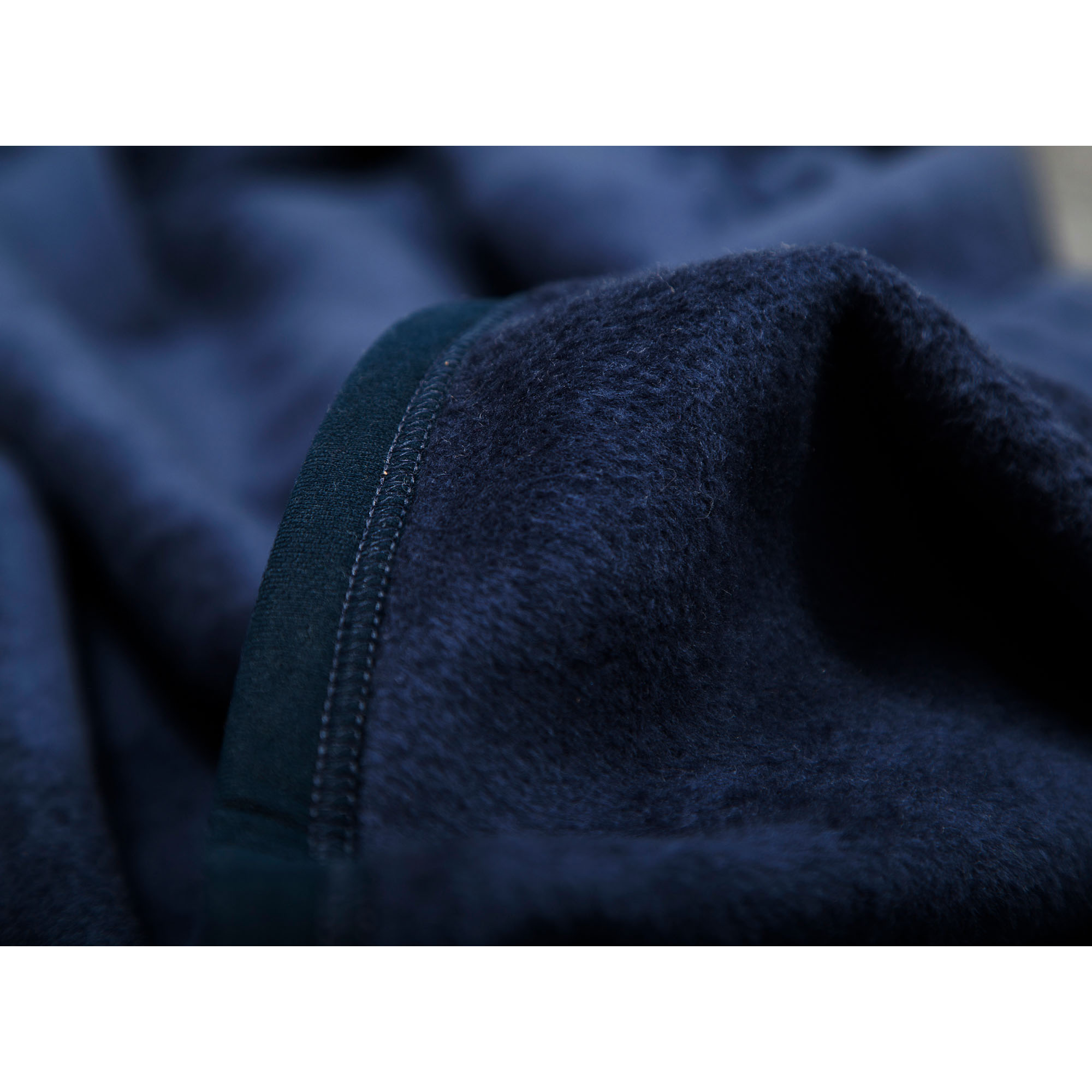 Nahaufnahme der mitternachtsblauen Wohndecke mit weichen Stofffalten und deutlich erkennbarer Textilstruktur