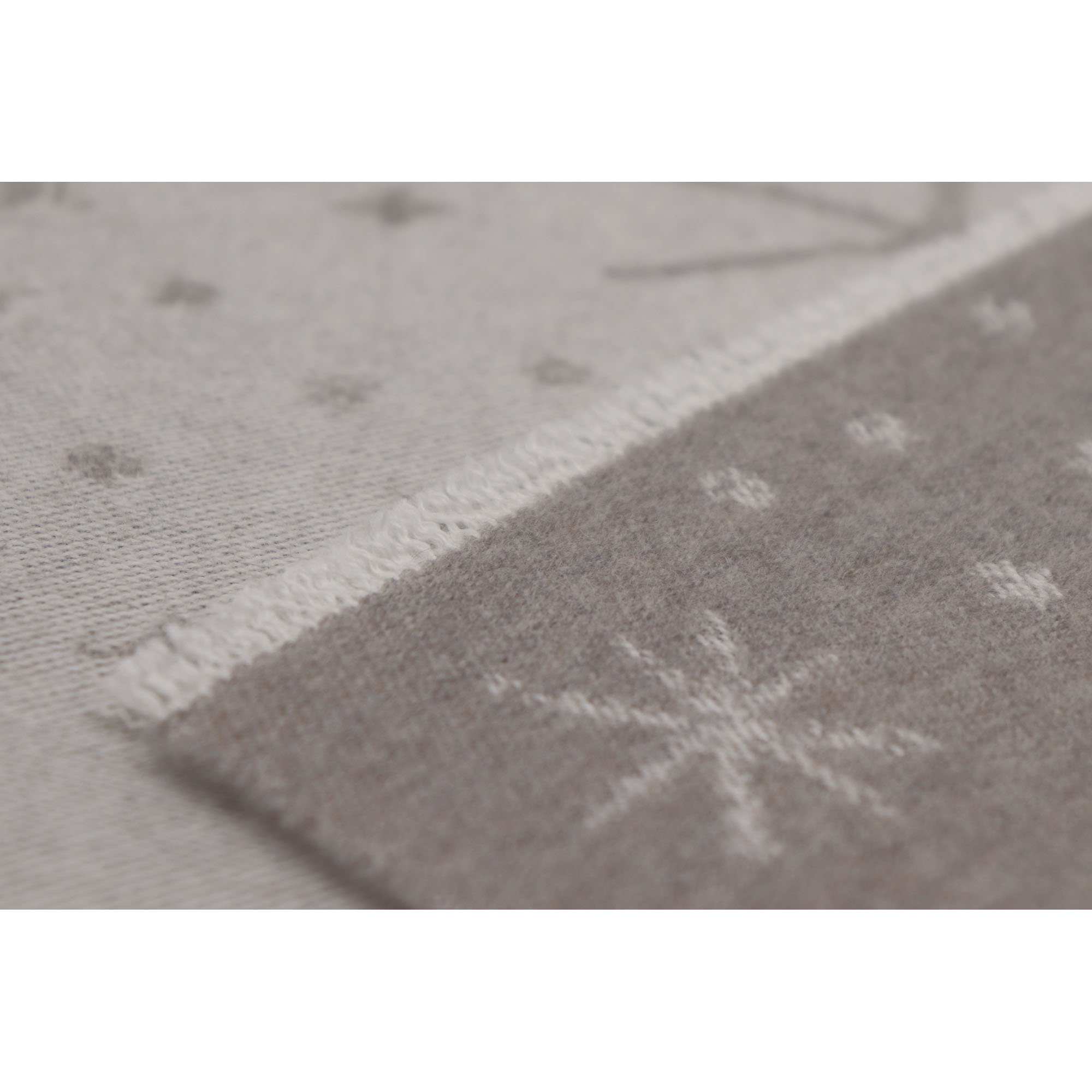 Detail einer Ecke der Babydecke Universe taupe mit hellem Sternmotiv und schmal eingefasstem Rand.