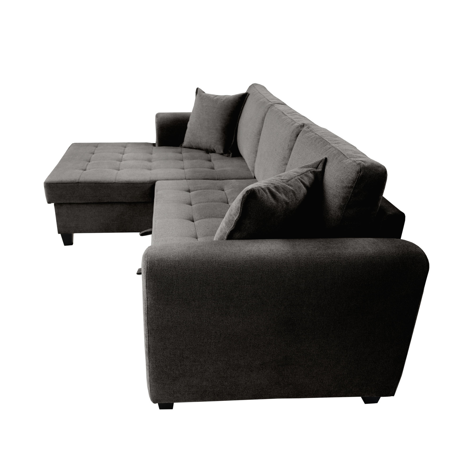 Freigestelltes graues Ecksofa aus erhöhter Seitenansicht mit abgerundeter Armlehne, gesteppten Sitzflächen, linker Ottomane und losen Kissen