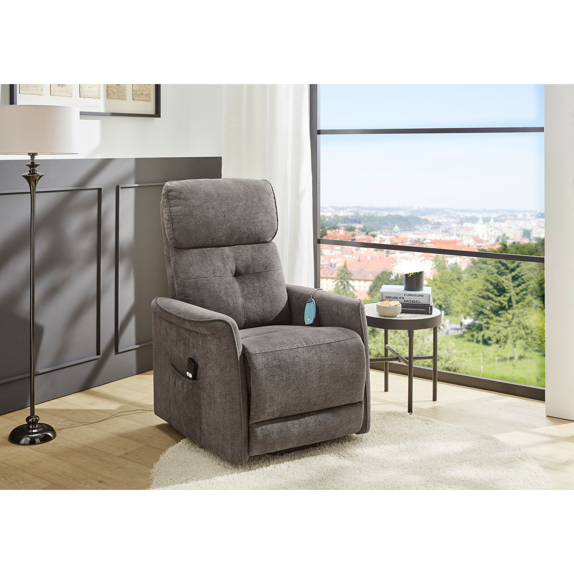 Helles Wohnzimmer mit grauem Relaxsessel, Beistelltisch und Panoramablick über die Stadt.