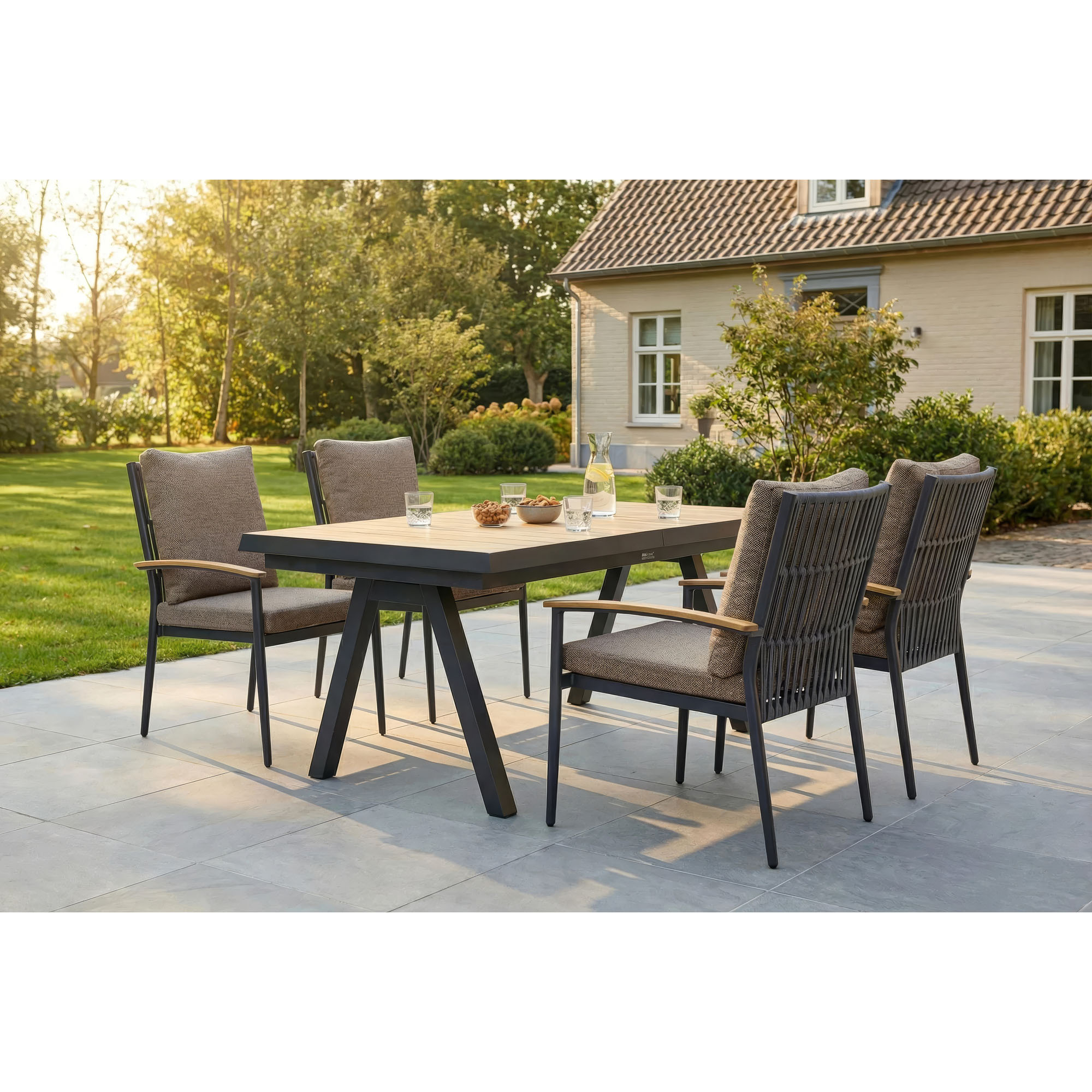 Gartentisch mit mehreren Gartenstühlen auf einer Terrasse im Außenbereich vor einem Gebäude