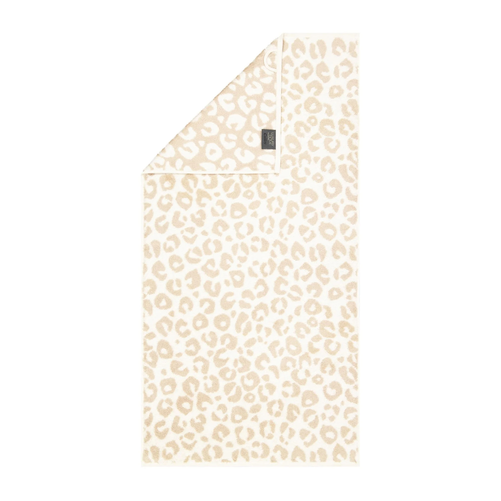 Handtuch in der Farbe Natur mit beigefarbenem Leopardenmuster auf hellem Grund und umgeschlagener Ecke; Vorderseite, Rückseite und kleines Textiletikett sind sichtbar.
