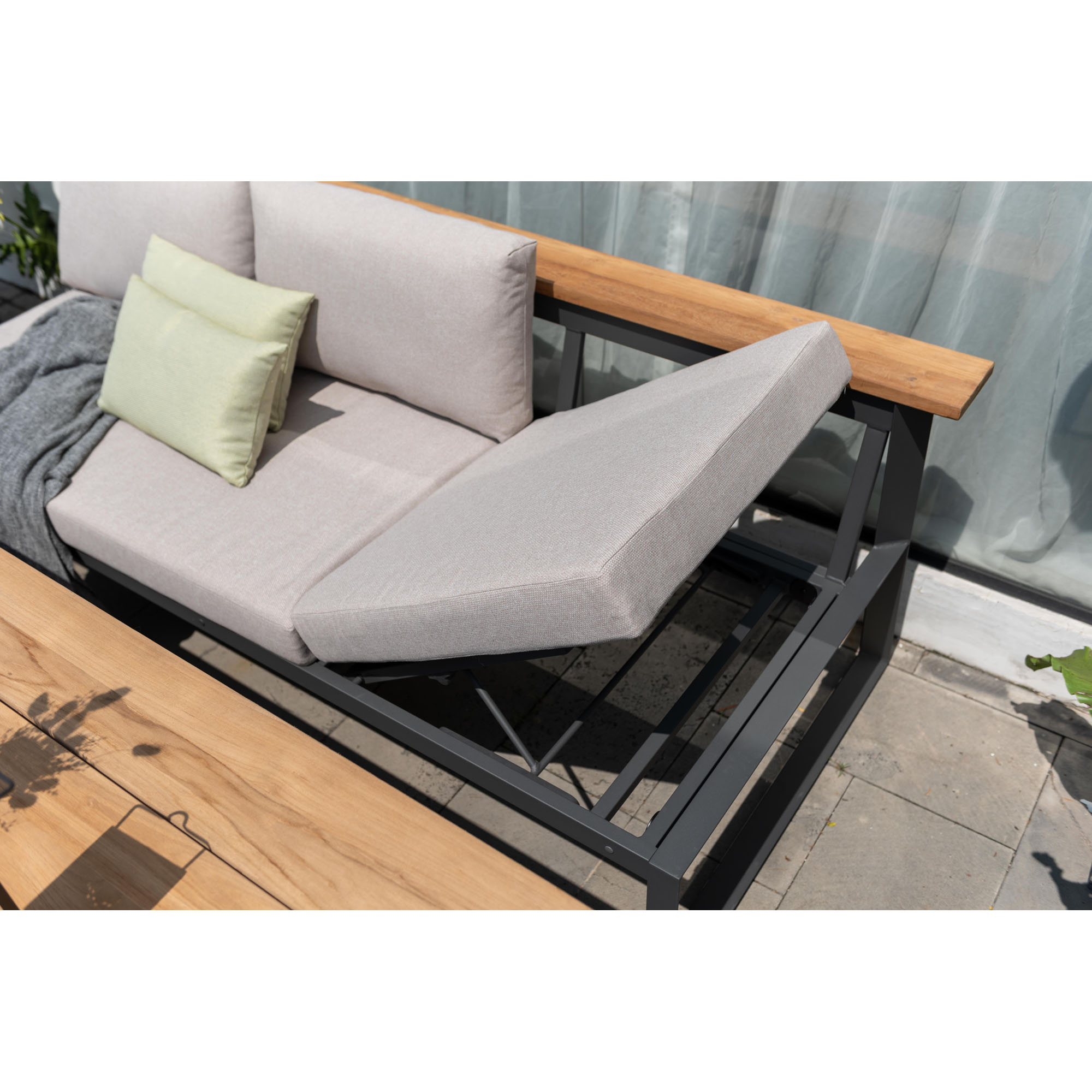 Detailaufnahme eines Gartensofas mit abgenommenem Sitzkissen, stabile Metallkonstruktion und Holzablage auf der Rückenlehne.
