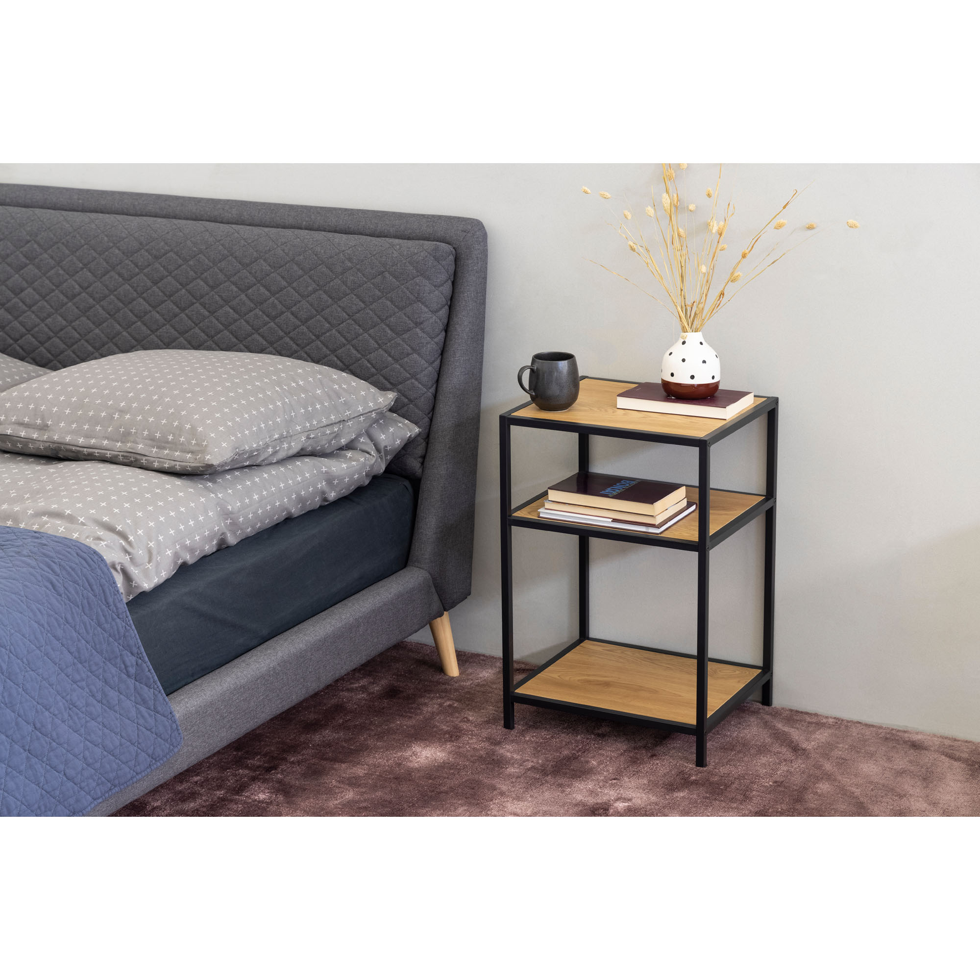 Nachttisch mit Platte in Wildeicheoptik und schwarzem Gestell, in einem eingerichteten Schlafzimmer neben einem Bett platziert