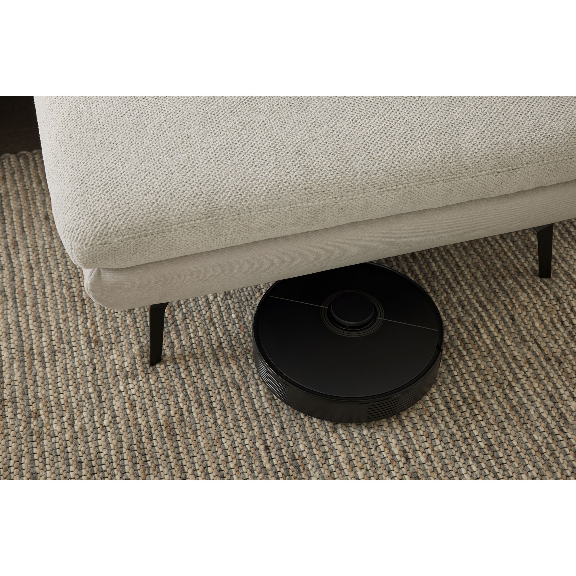 Unterseite der Recamiere der Interliving Sofa Serie 4304 mit sichtbarer Bodenfreiheit und Staubsaugerroboter darunter