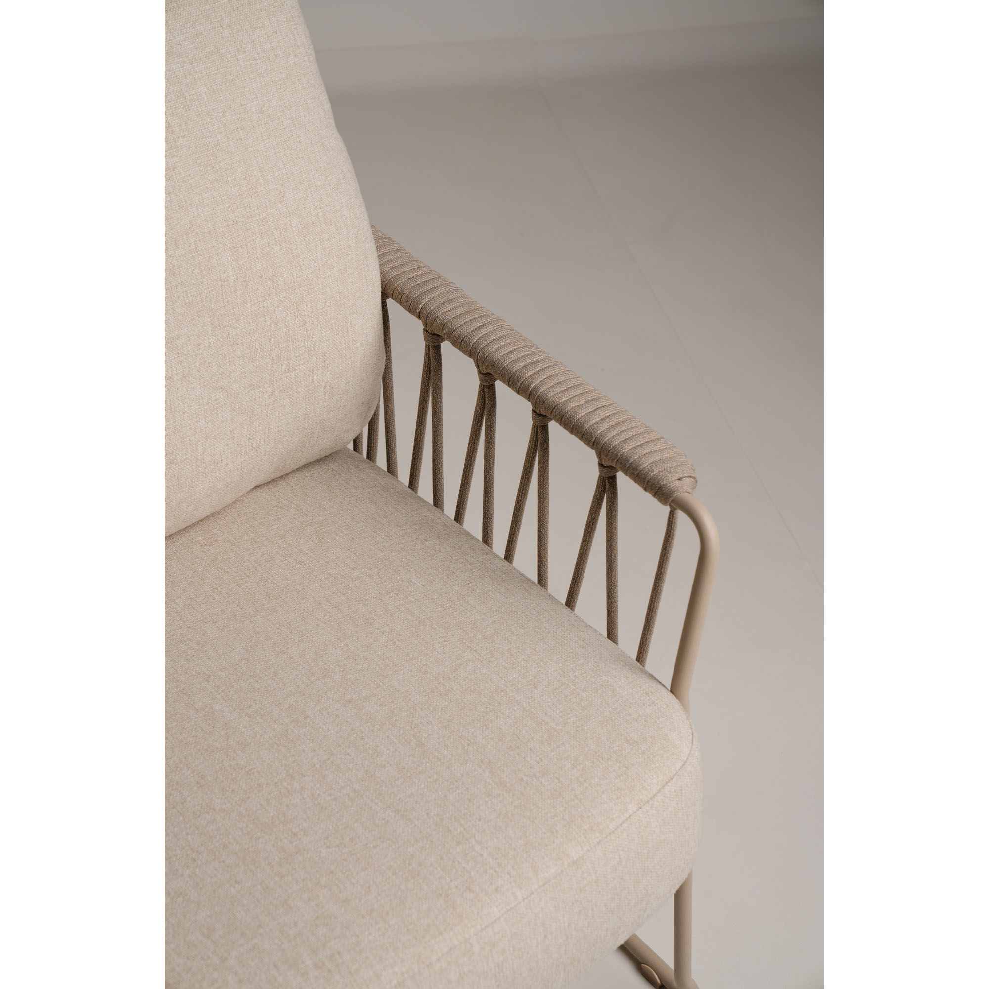 Nahaufnahme des hellen Polsters und der Armlehne eines Lounge Chairs mit Gestell in Champagnerfarbe