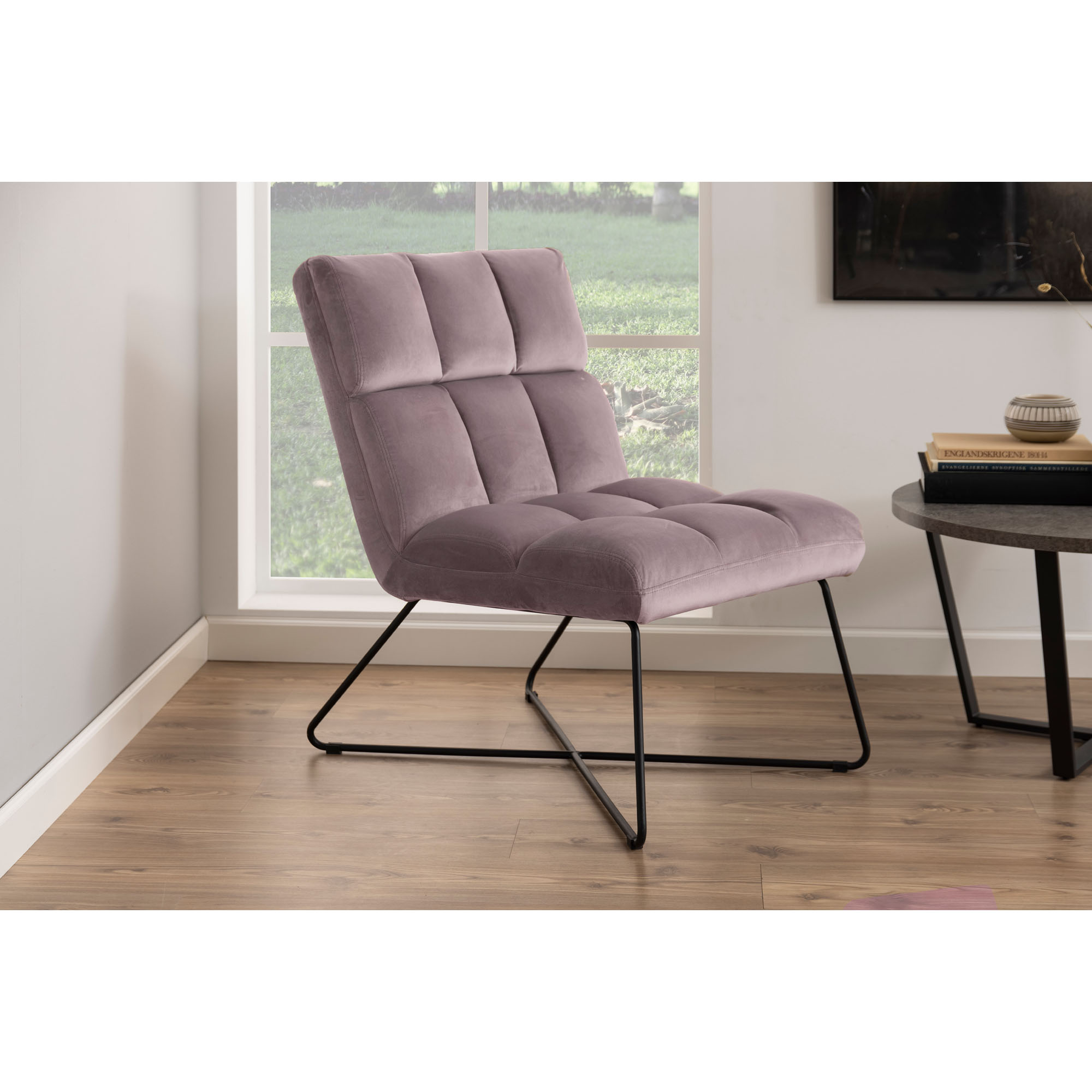 Moderner Loungestuhl mit Bezug in dusty rose und schwarzem Gestell, dekoriert in einem hellen Wohnbereich