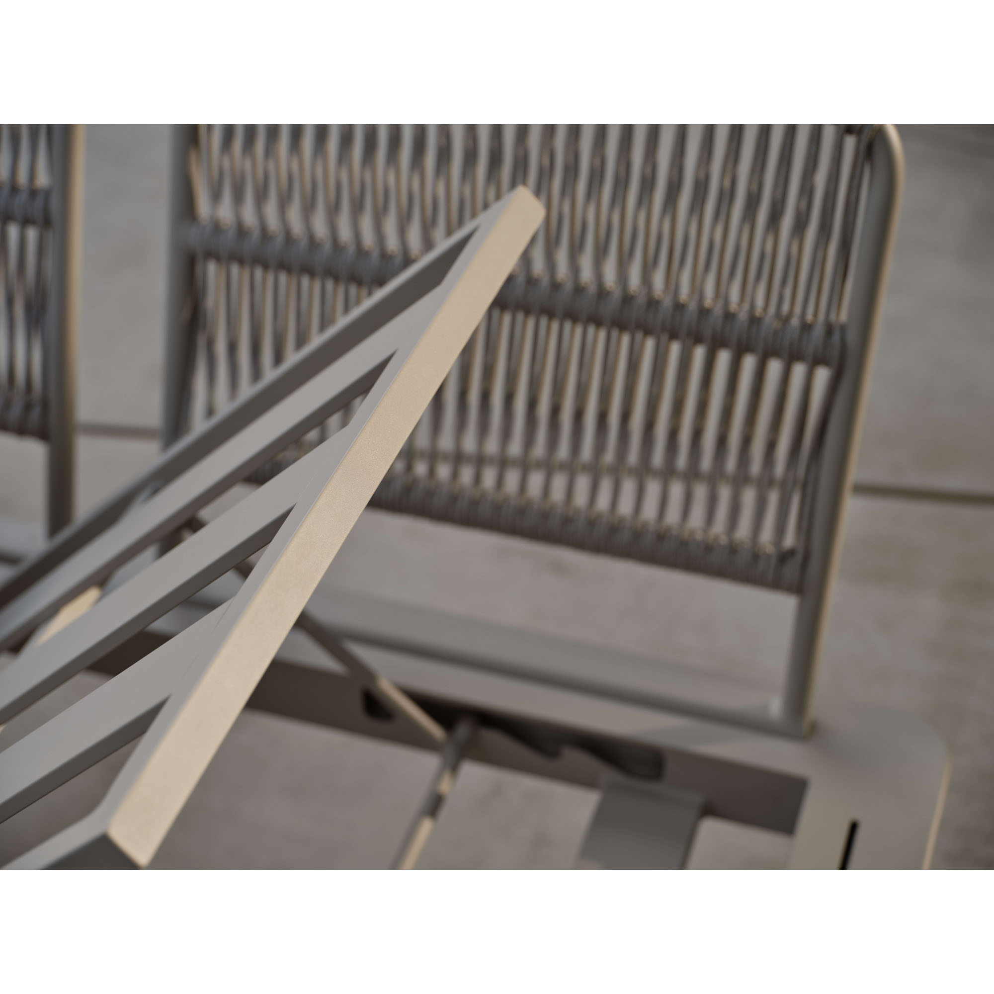 Detailansicht eines Metallgestells eines Outdoor Sofas mit sichtbarer Verbindung und geflochtener Rückenlehne im Hintergrund.