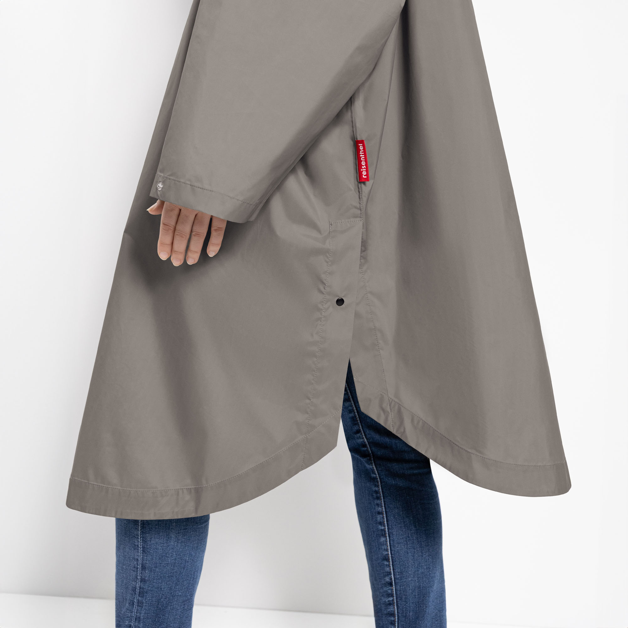 Seitliches Detail des grauen Reisenthel Regenponchos mit Druckknopfverschluss