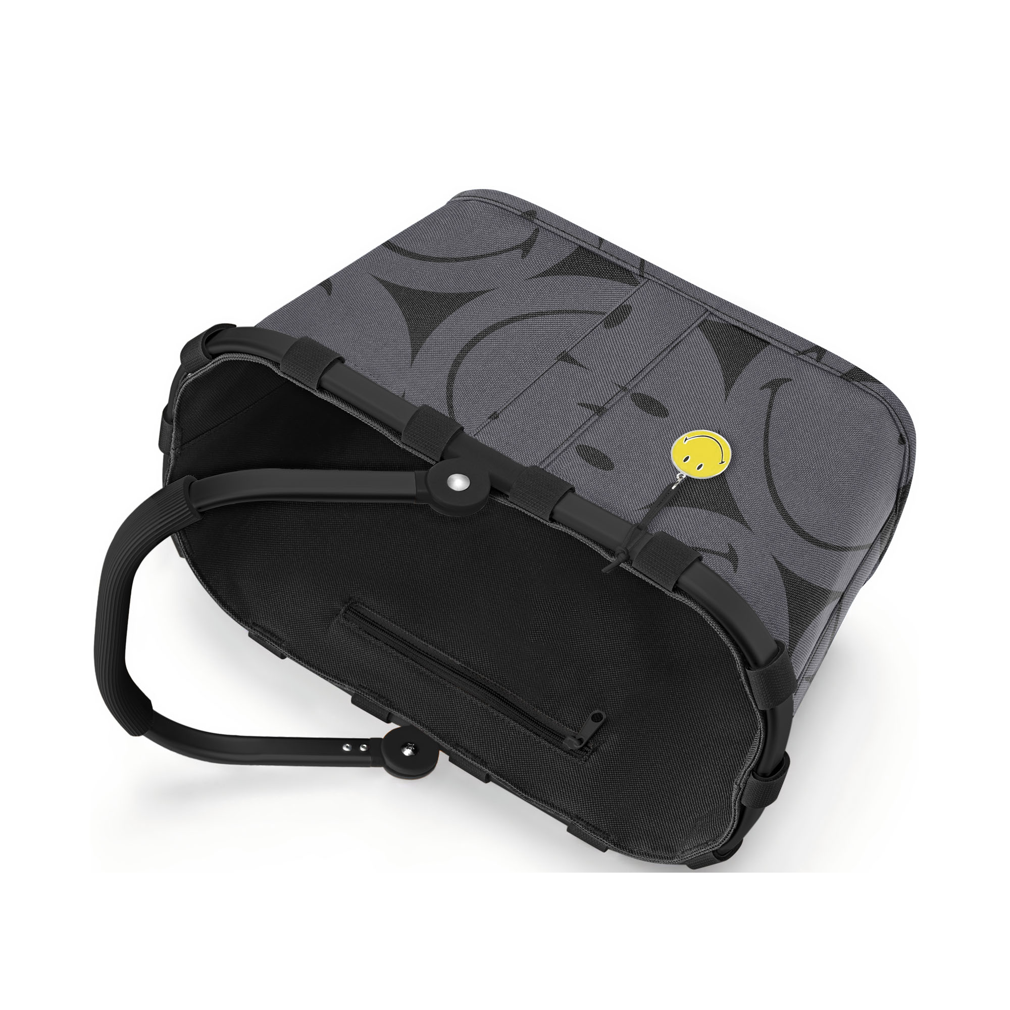 Kleiner Einkaufskorb von Reisenthel, Modell Carrybag XS, in Grau mit großflächigem Smiley-Muster, auf die Seite gelegt mit sichtbarem Rahmen und eingeklapptem Griff.