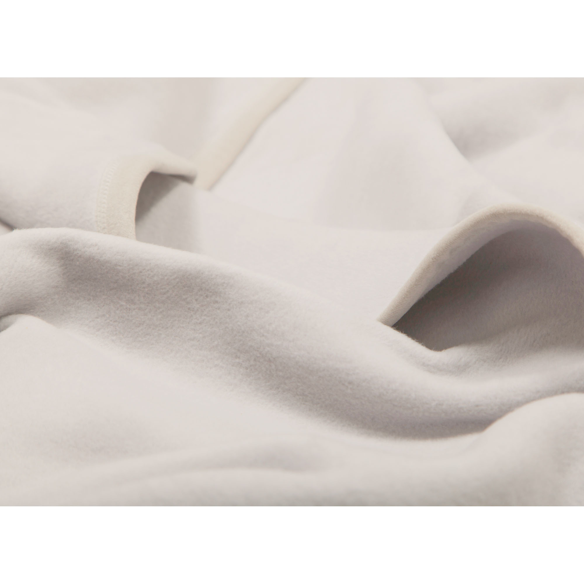 Nahaufnahme der Wohndecke CottonSense silber mit weichen hellgrauen Stofffalten und gleichmäßiger Oberfläche.