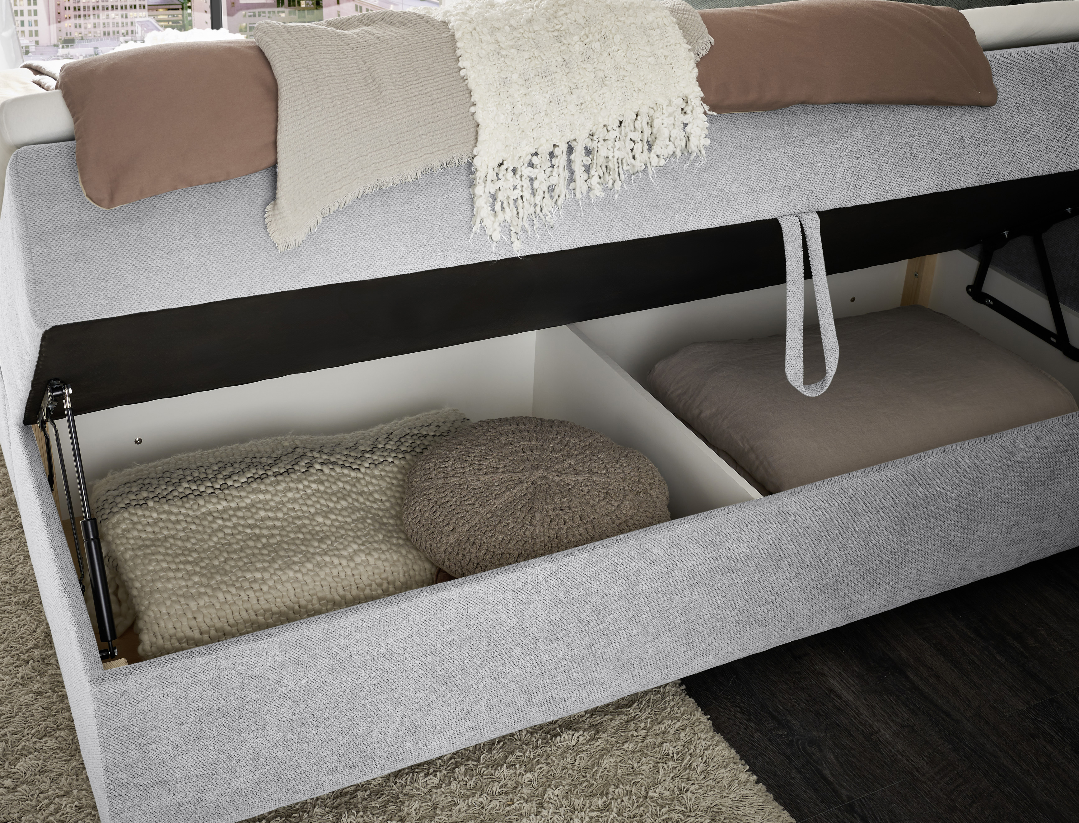 Detailaufnahme des geöffneten Bettkastens vom Boxspringbett „Curio 80 Silver“ in einem eingerichteten Schlafzimmer, Stauraumfunktion im Nahformat sichtbar