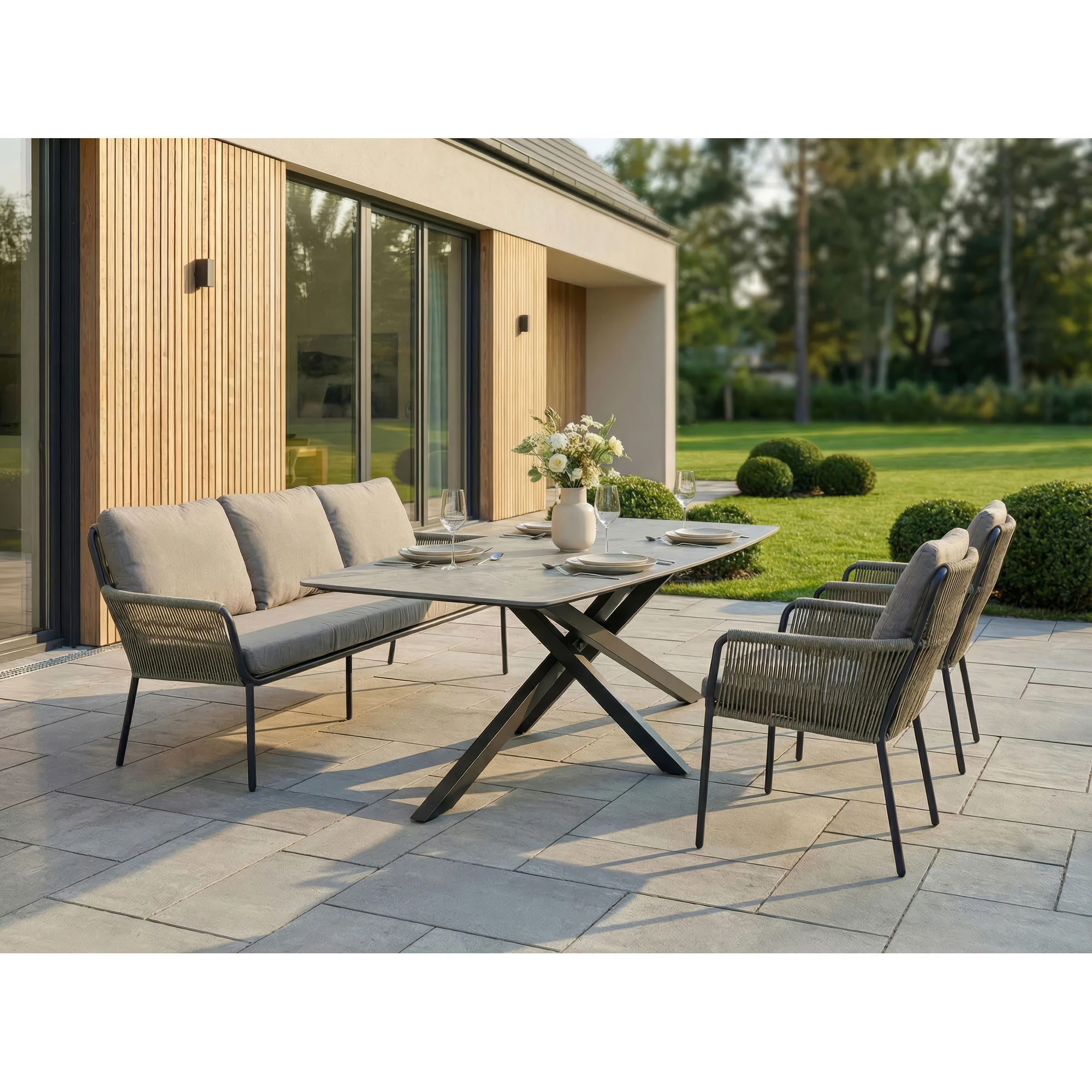 Gartenbank mit passenden Stühlen und Tisch im Außenbereich auf einer Terrasse