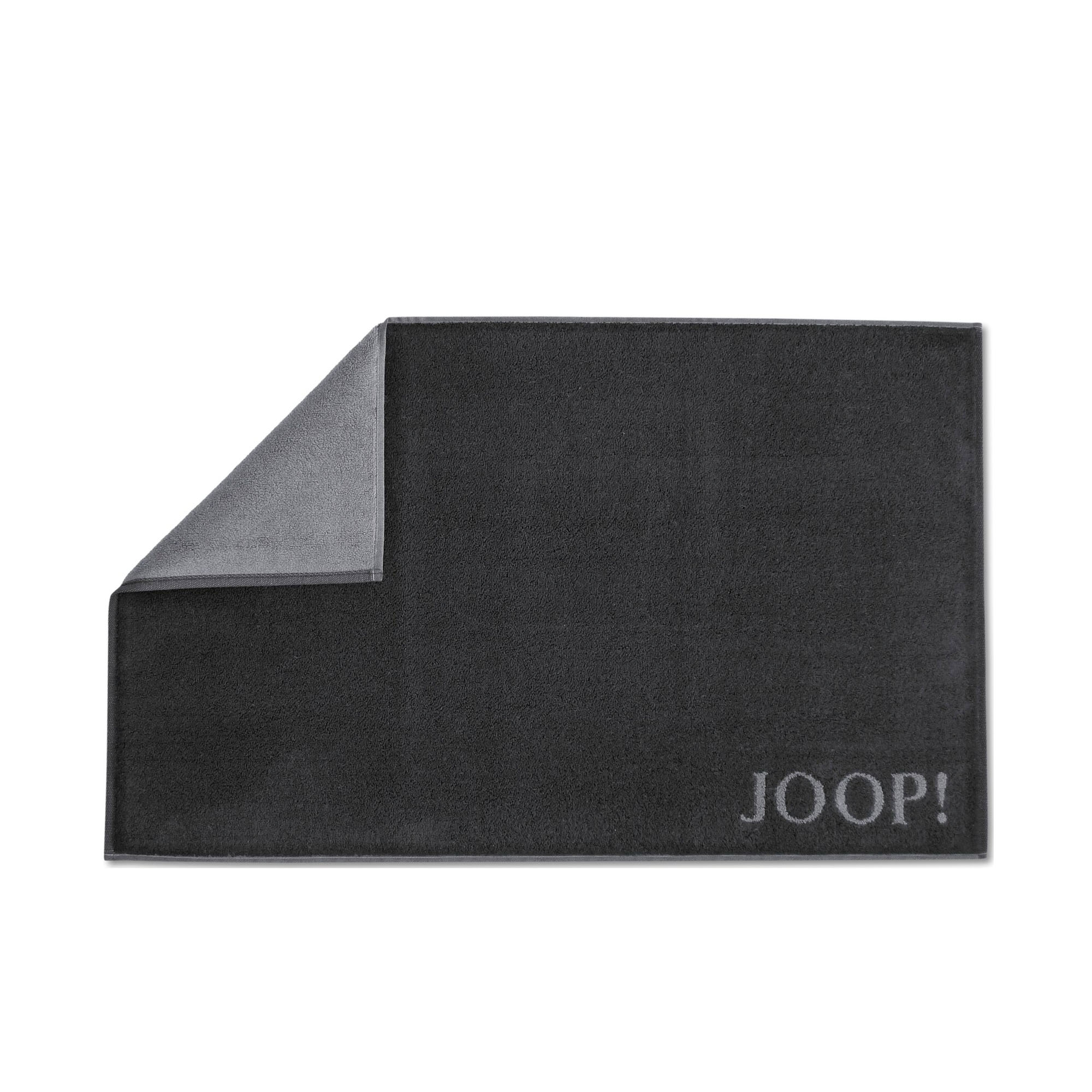 Schwarz-anthrazitfarbener JOOP! Badematte, 50 × 80 cm, rechteckig flach dargestellt; eine Ecke ist umgeschlagen und zeigt die graue Rückseite, rechts unten steht der JOOP!-Schriftzug.