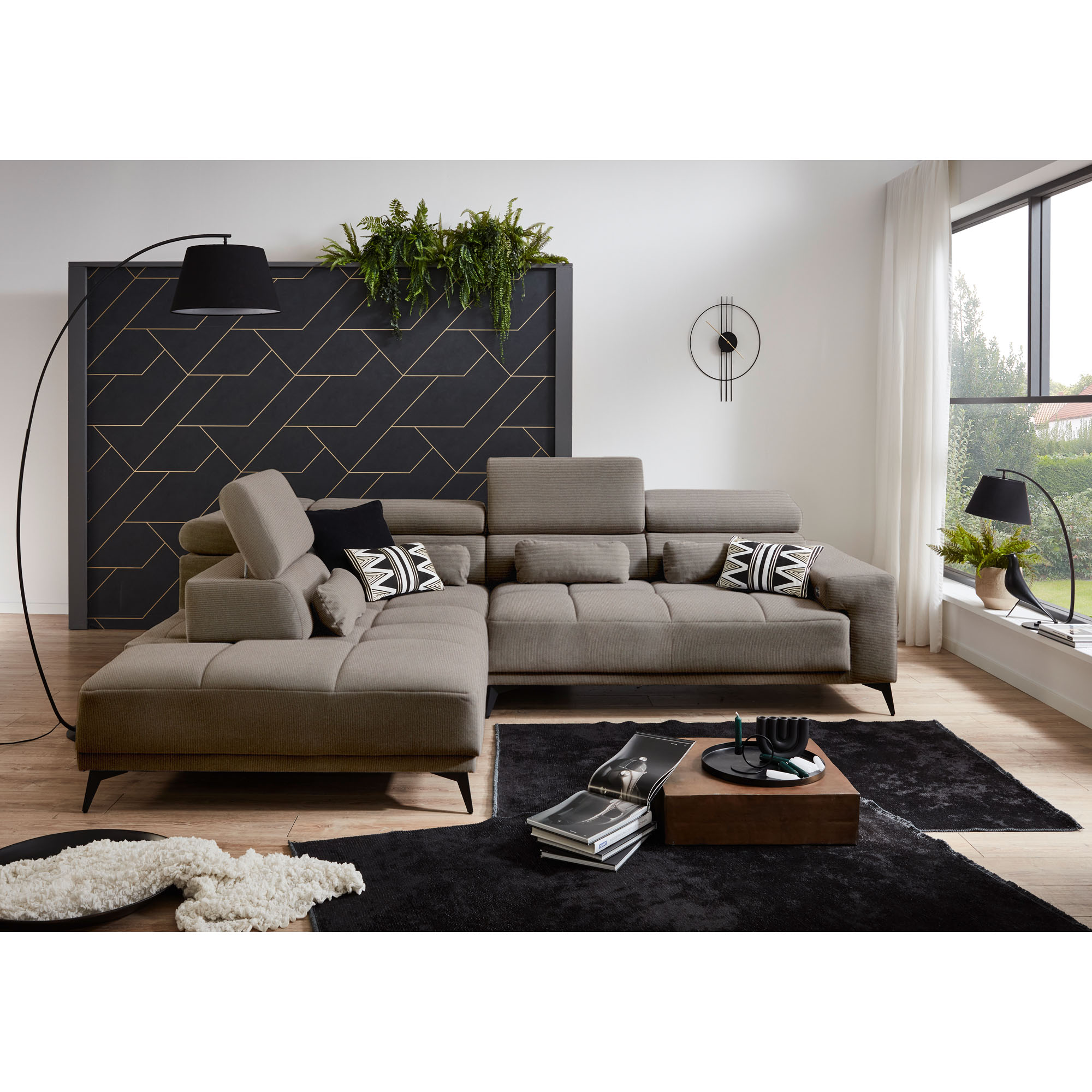Hellgraues Ecksofa mit Ottomane links und unterschiedlich eingestellten Kopfstützen in einem modernen Wohnzimmer