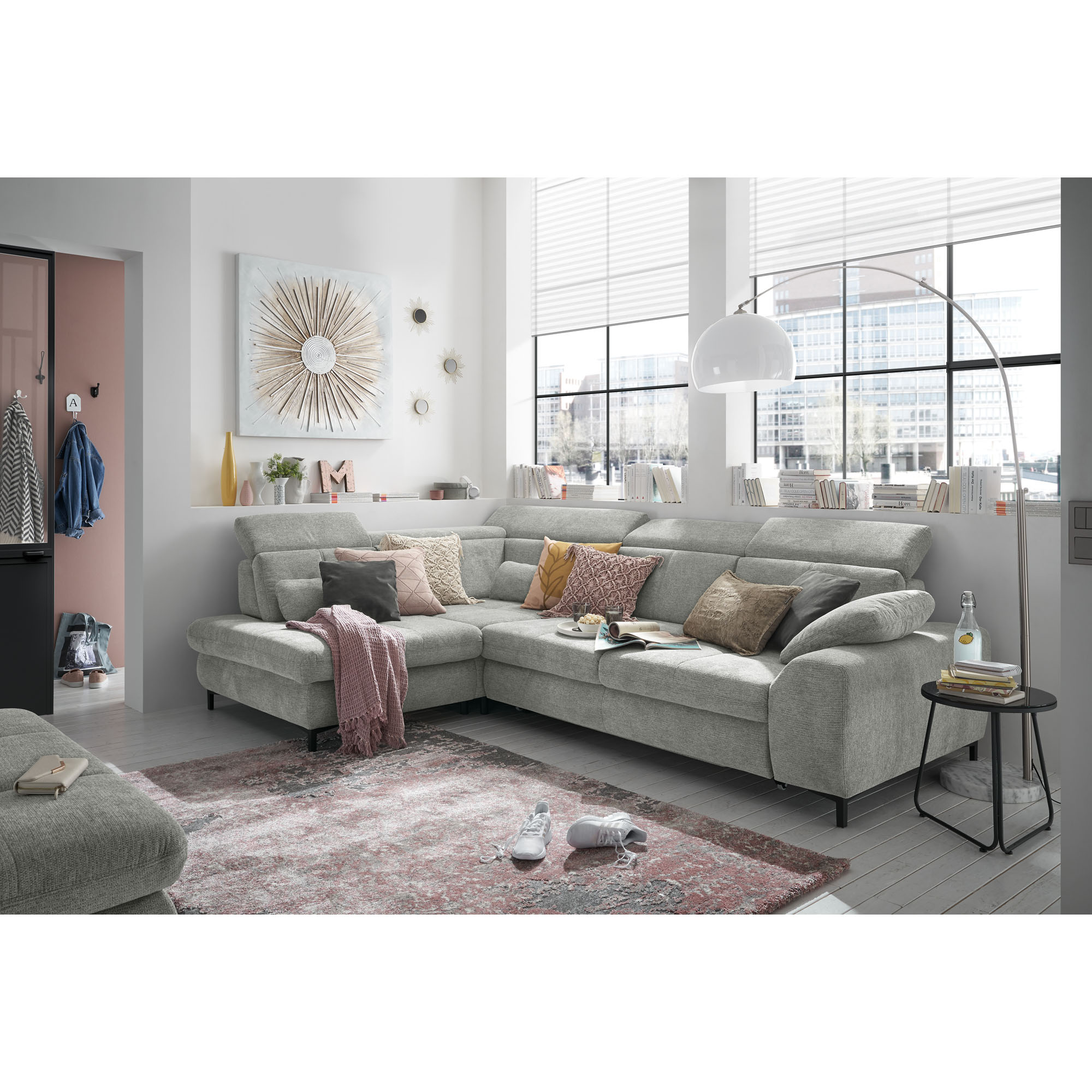 Ecksofa Musterring SO 3400 mit Longchair in moderner Wohnzimmerszene mit Kissen, Teppich und großer Fensterfront