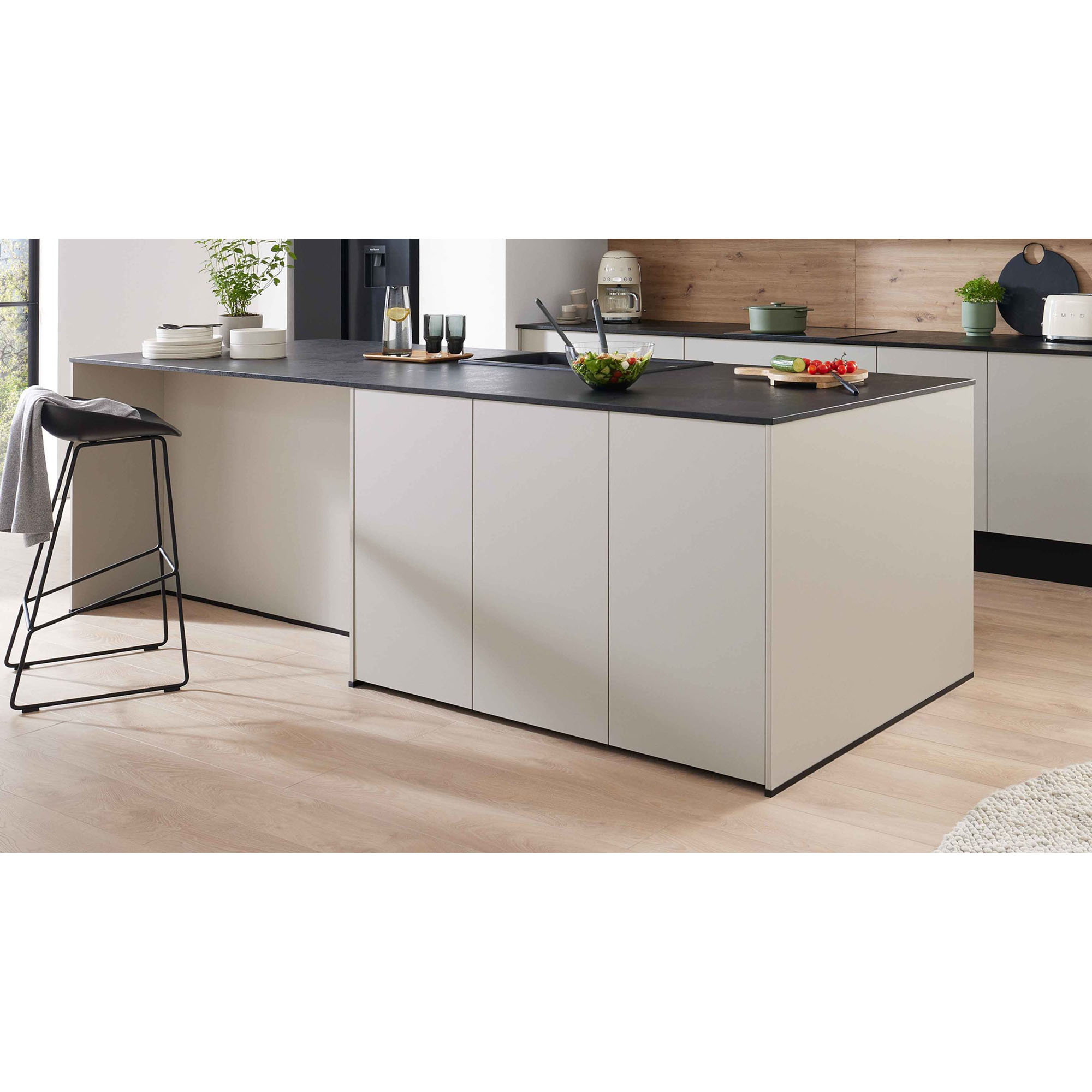 moderne Kücheninsel mit dunkler Arbeitsplatte, Barhocker und Dekoration in heller Küche