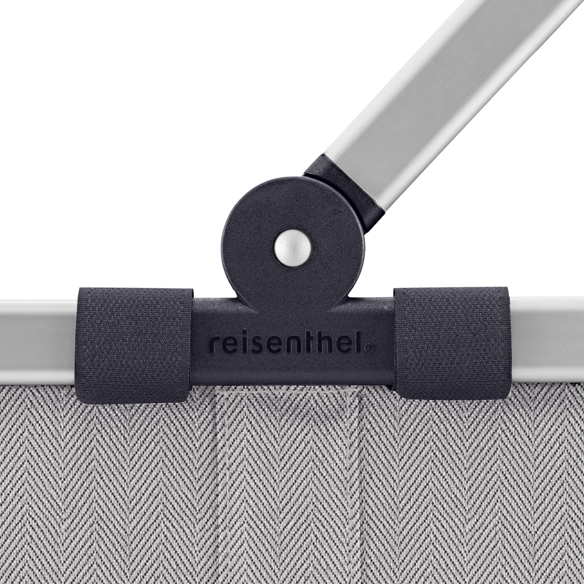 Einkaufskorb von Reisenthel, Modell Carrybag, in Hellgrau mit feinem Fischgrätmuster, als Nahaufnahme des Gelenks zwischen Aluminiumgriff und Korbrand.
