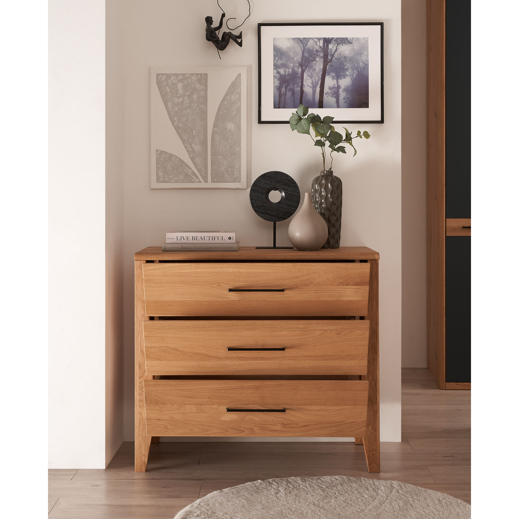 Kommode aus Holz mit drei Schubladen in einem modern eingerichteten Schlafzimmer