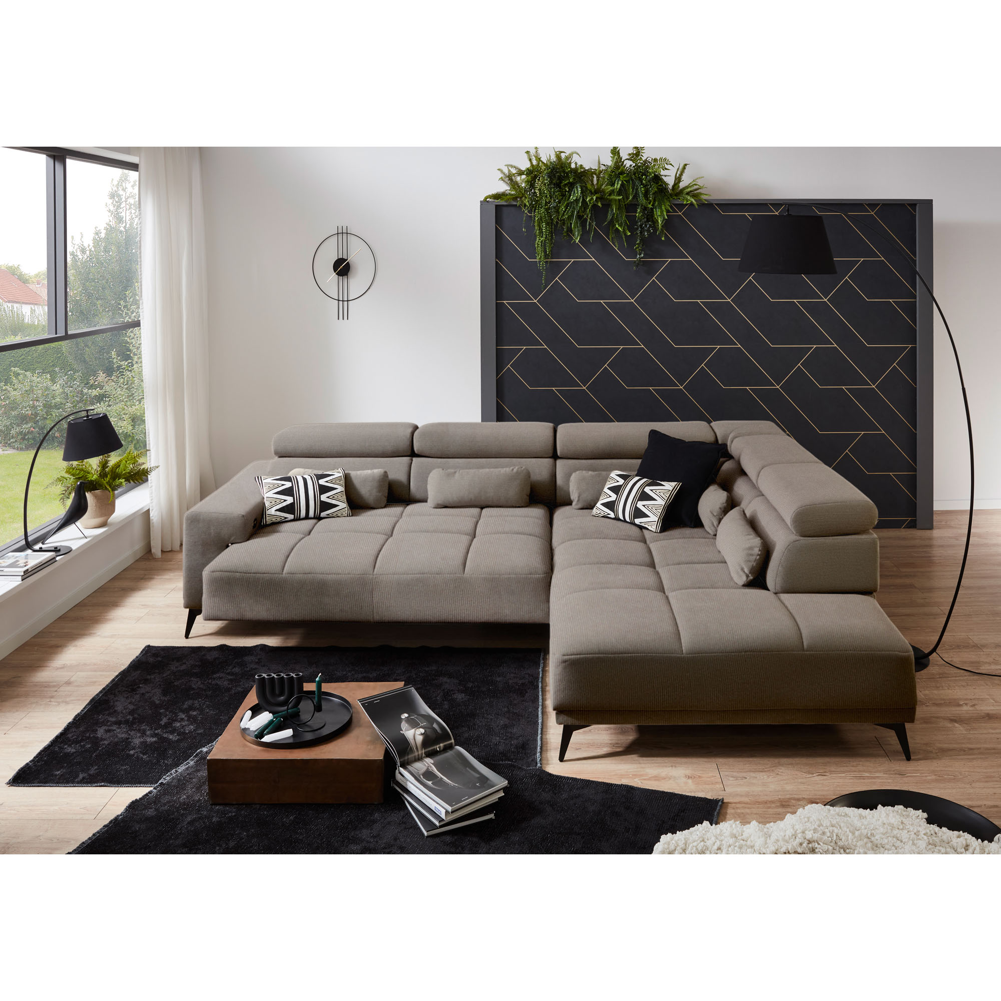 Hellgraues Ecksofa mit Ottomane rechts und ausgezogener Sitzfläche in einem modernen Wohnzimmer mit schwarzem Teppich