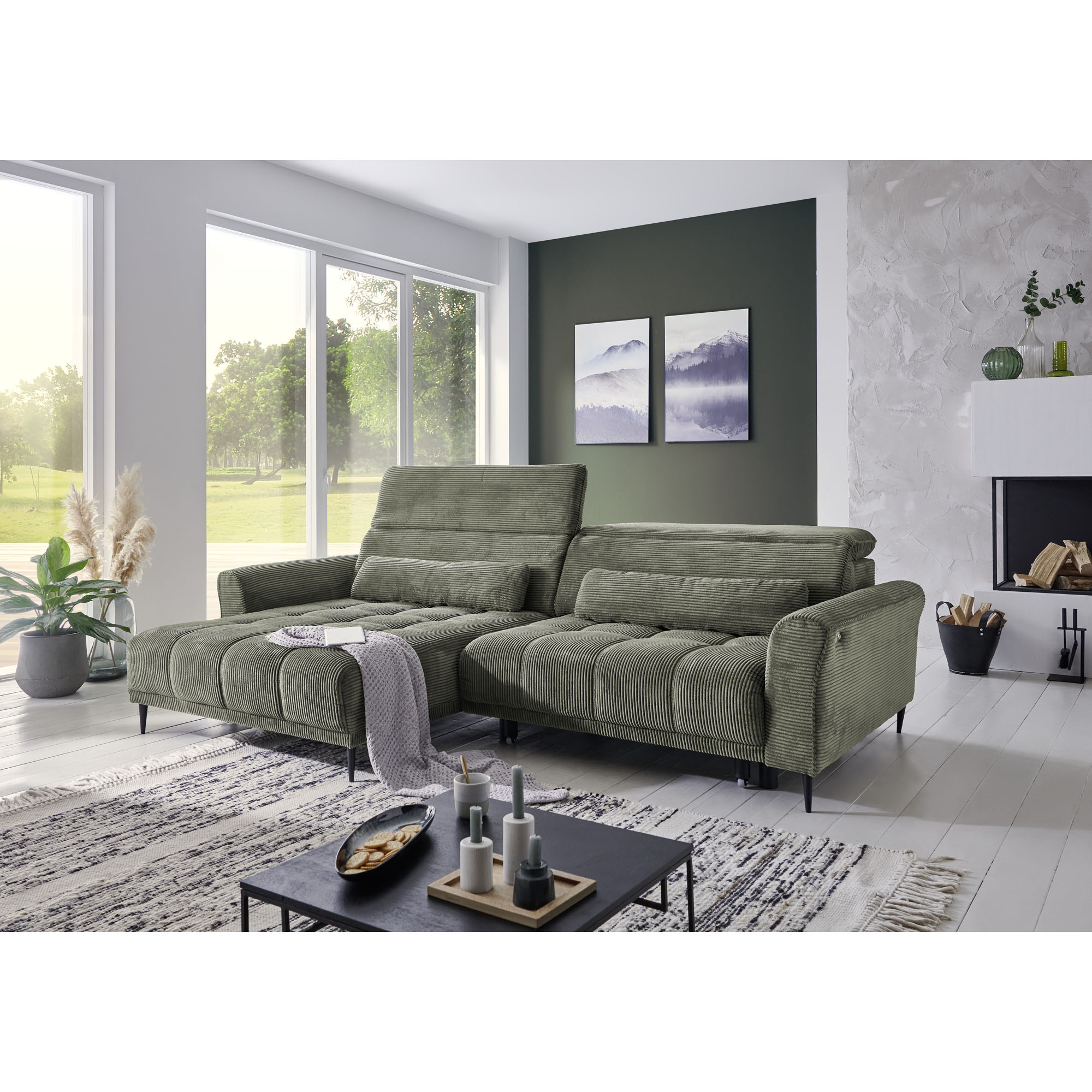 Helles Wohnzimmer mit modernem Ecksofa in grünem Cordstoff, dekoriert mit Pflanzen und Wandbildern.