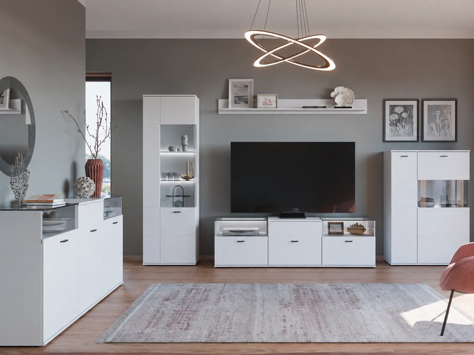 Komplett eingerichtetes Wohnzimmer mit moderner Wohnwand in Weiß bestehend aus TV-Lowboard, beleuchteter Vitrine, Sideboard, Wandregal und Couchtisch vor grauer Wand