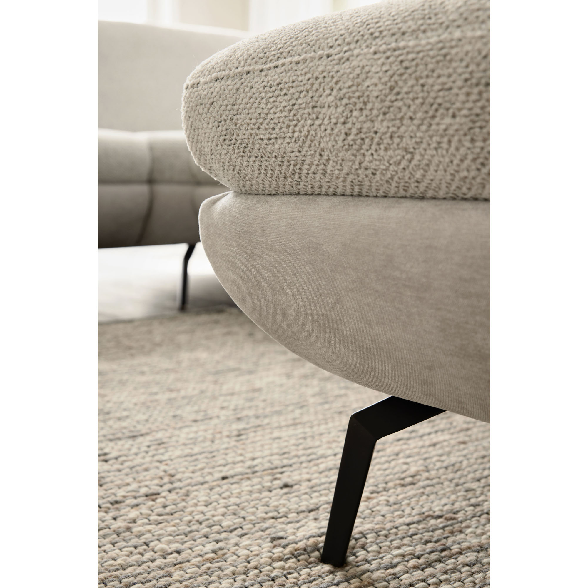 Nahaufnahme eines schwarzen Metallfußes der Interliving Sofa Serie 4304 auf Teppichboden