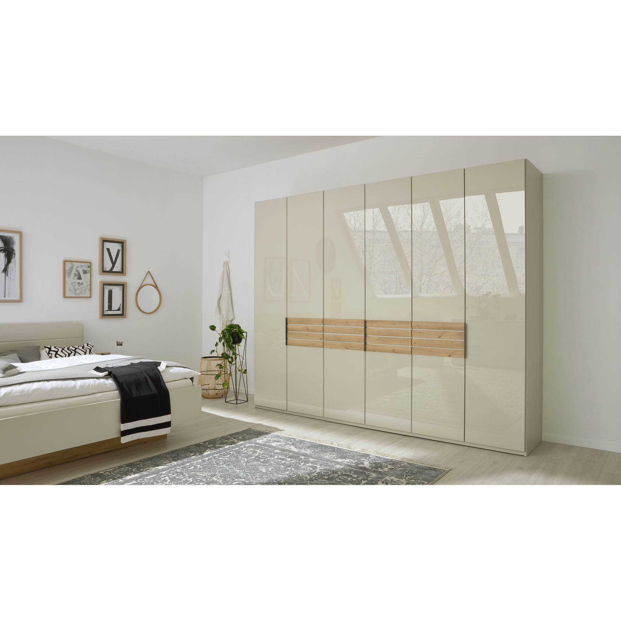 Moderner Kleiderschrank Interliving 1026 mit glänzenden Fronten und horizontaler Holzapplikation in einem hell eingerichteten Schlafzimmer