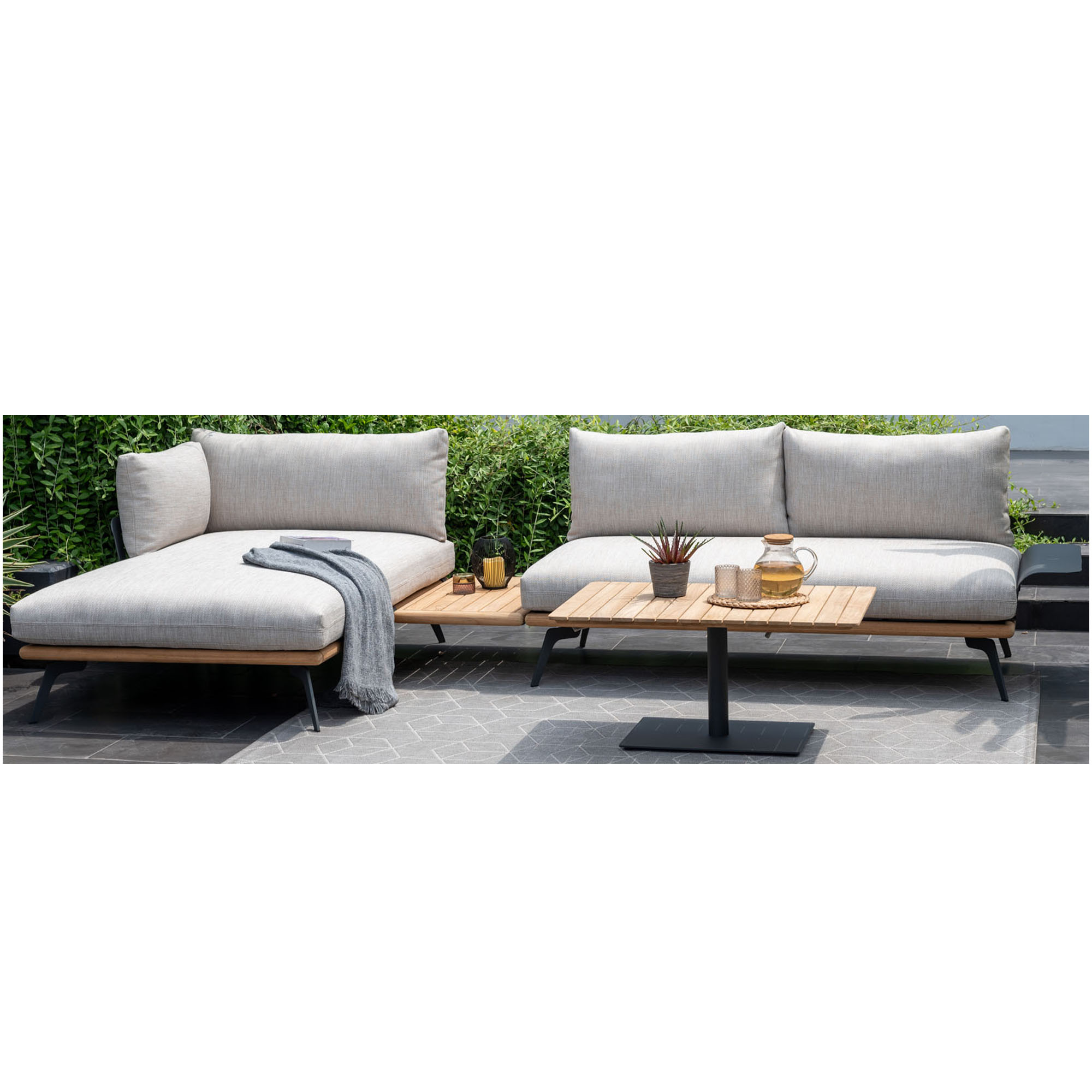 Garten Loungegruppe mit Ecksofa, Liegeelement und Tisch auf einer gepflasterten Terrasse