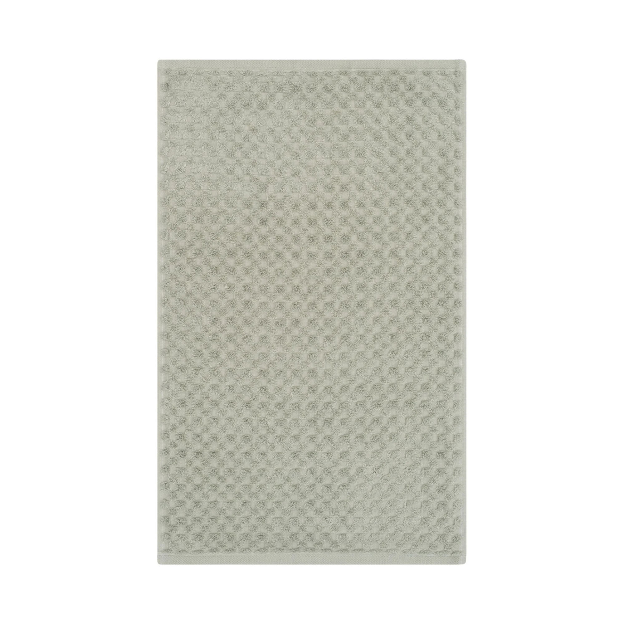 Gästetuch in der Farbe Seegras, flach auf weißem Hintergrund gezeigt; die fein geometrisch strukturierte Oberfläche ist über die gesamte Fläche sichtbar.