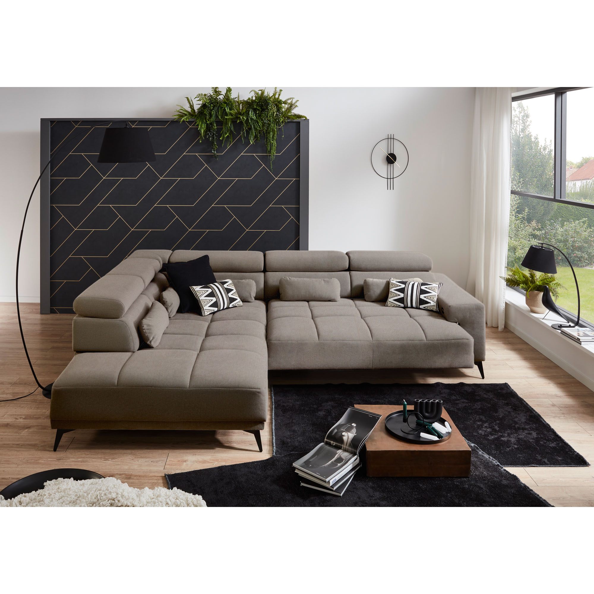 Hellgraues Ecksofa mit Ottomane links und ausgezogener Sitzfläche in einem modernen Wohnzimmer mit schwarzem Teppich
