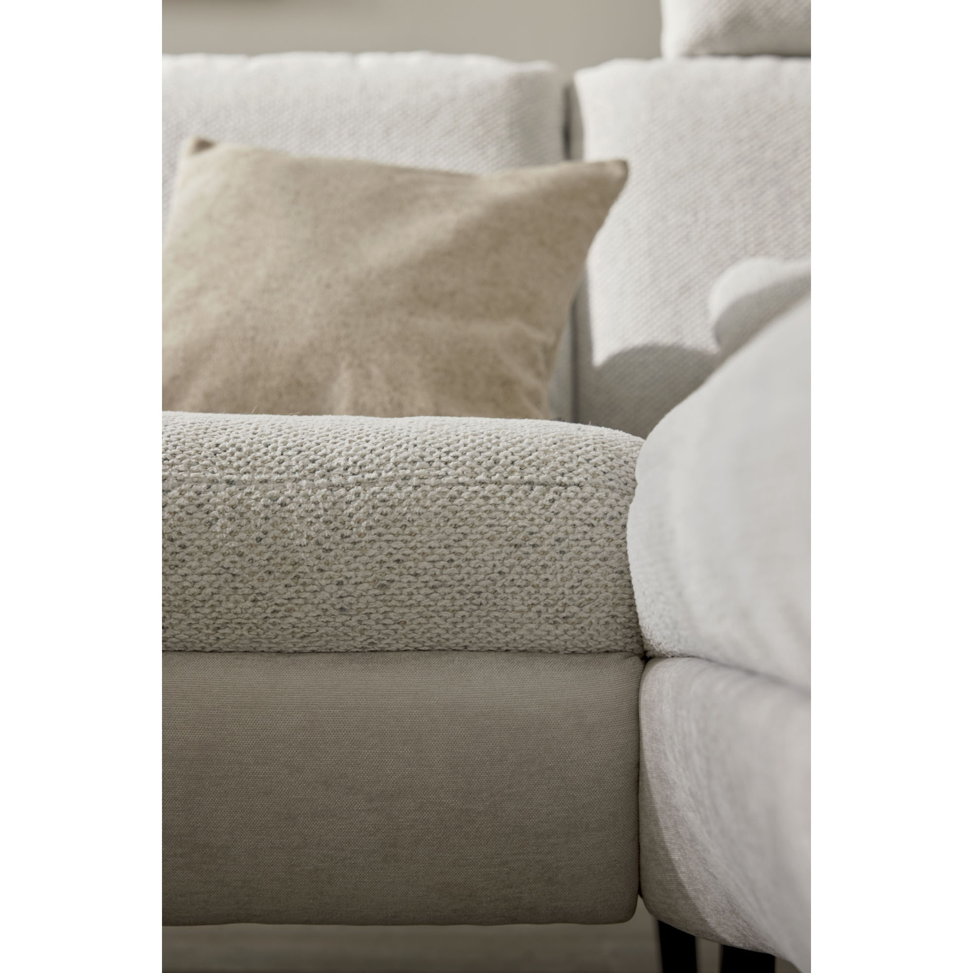 Detailansicht eines Sitzkissens der Interliving Sofa Serie 4304 mit dekorativem Kissen