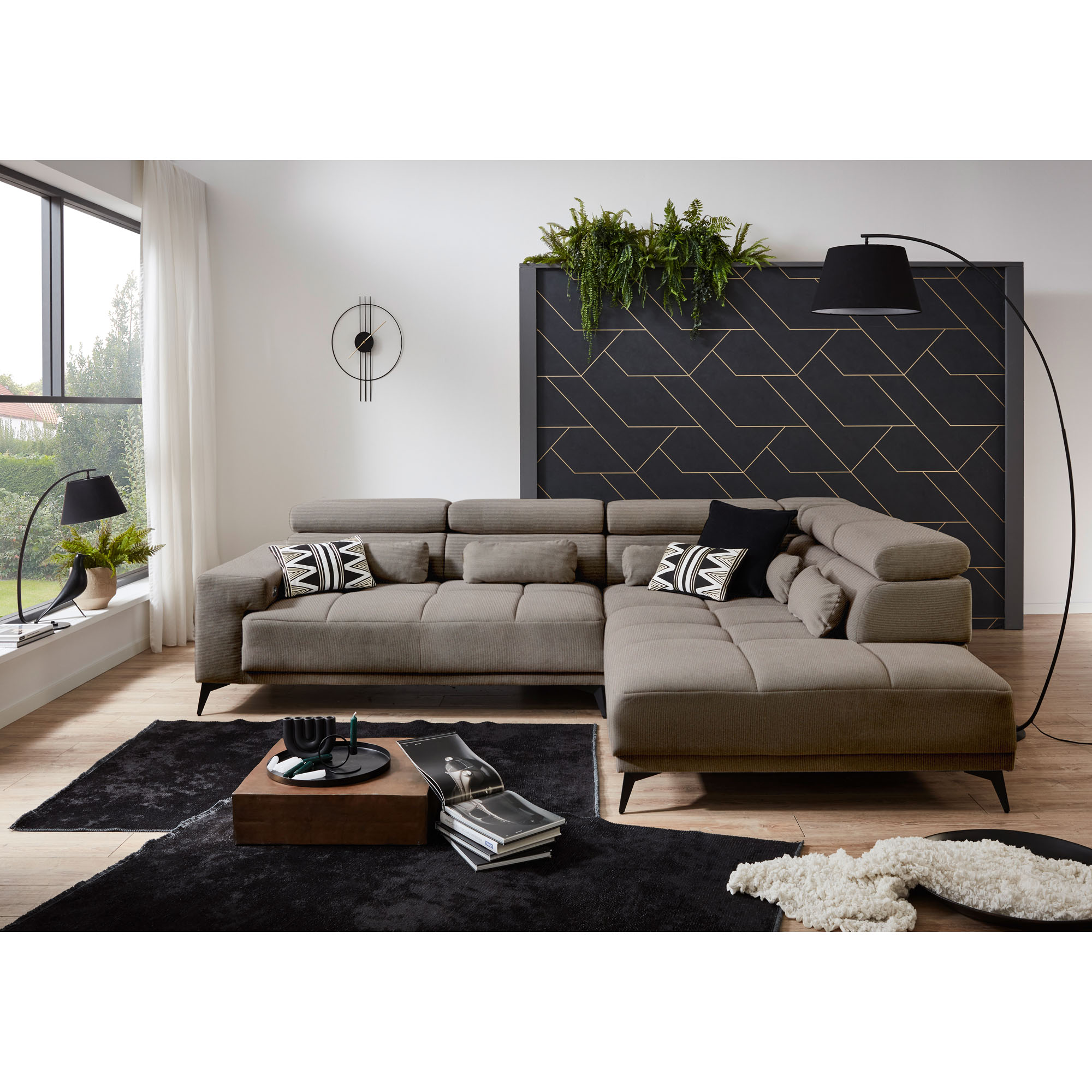 Hellgraues Ecksofa mit Ottomane rechts, verstellbaren Kopfstützen und Dekokissen in einem modern eingerichteten Wohnzimmer