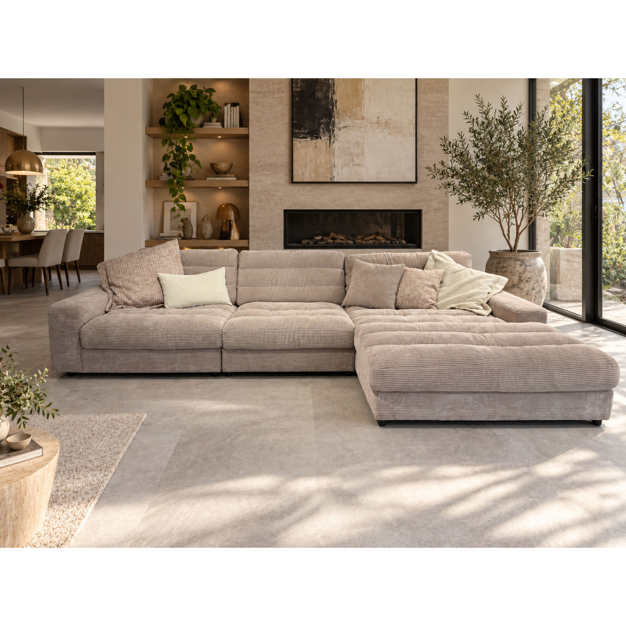 Moderne Polstergarnitur in Beige mit Ottomane in einem hellen Wohnzimmer mit Teppich, Couchtisch und Pflanzen