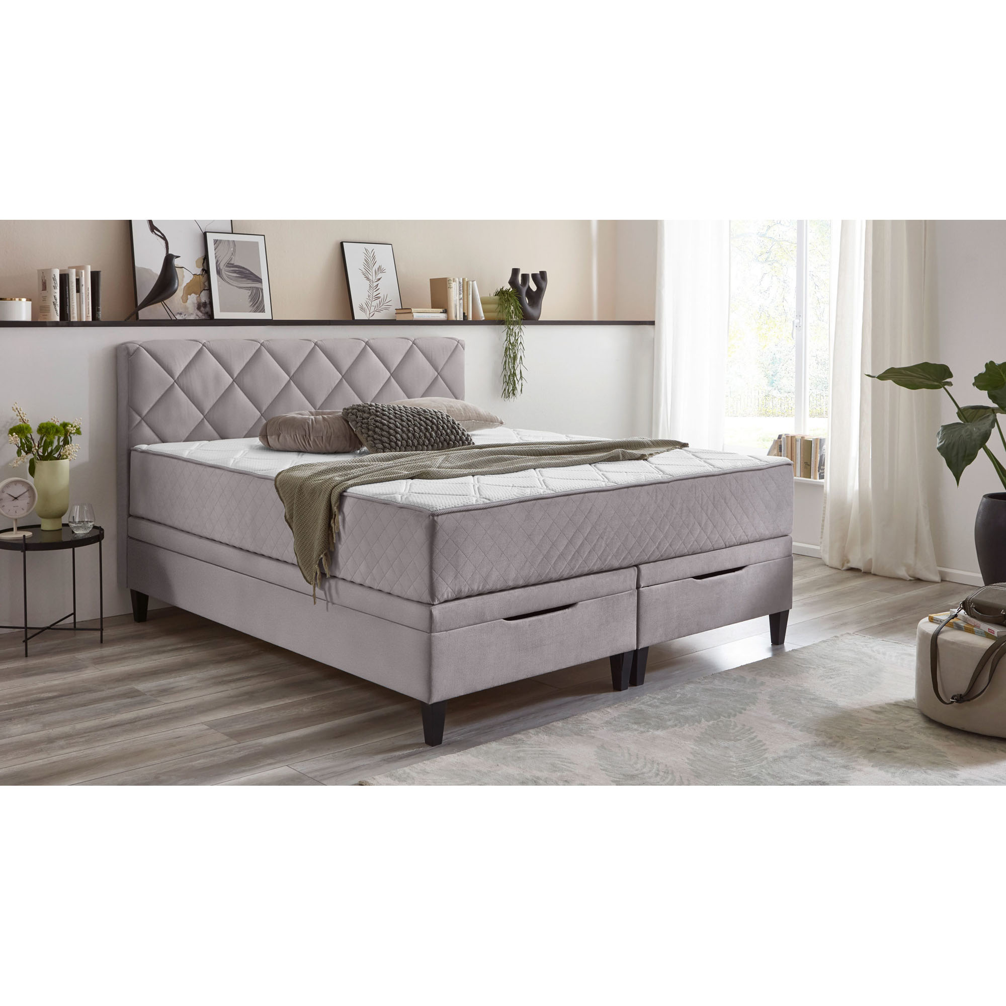 Boxspringbett mit fest vernähtem Matratzentopper in einem eingerichteten Schlafzimmer