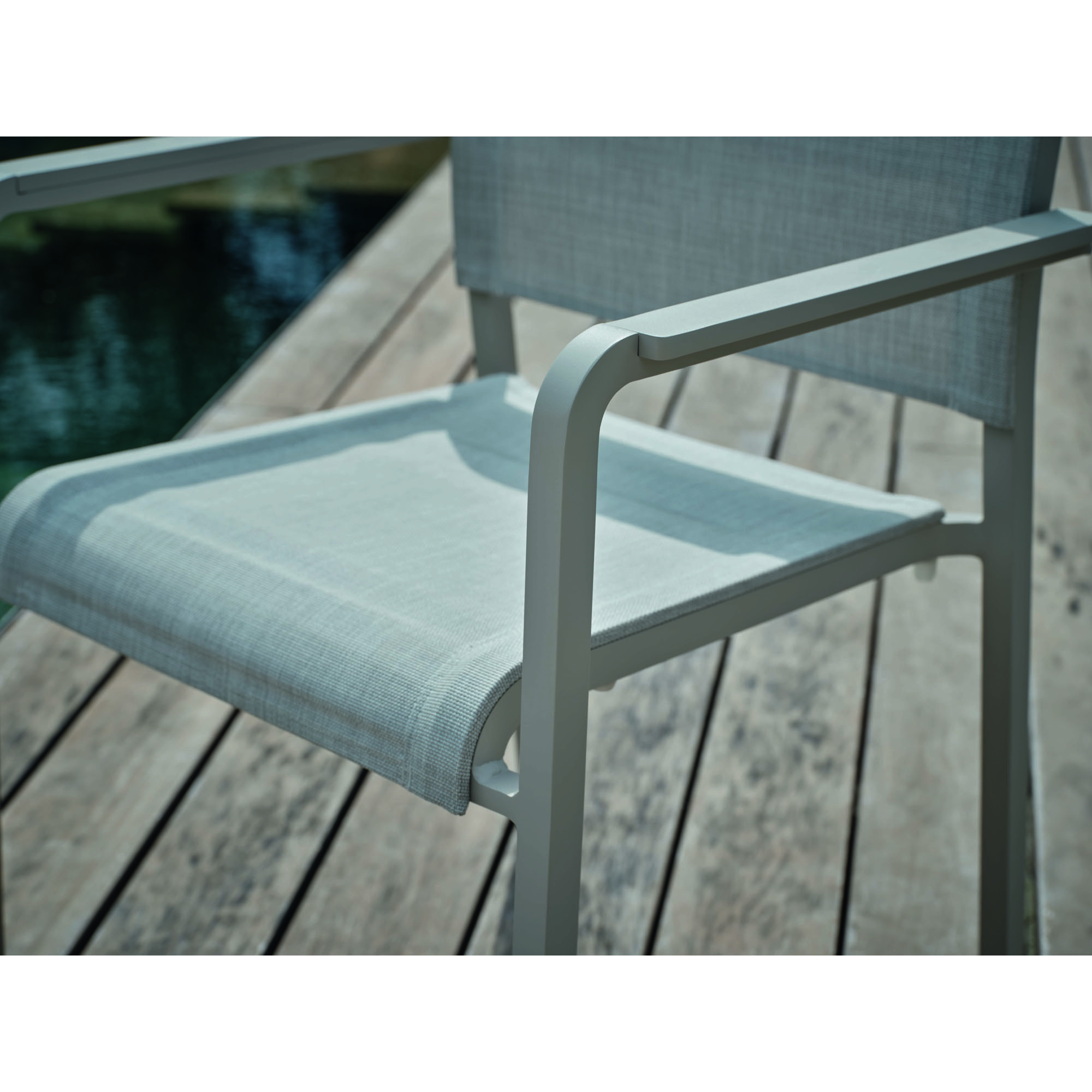 Detailaufnahme der Sitzfläche eines Gartenstuhls mit gespanntem Textilgewebe und Metallrahmen