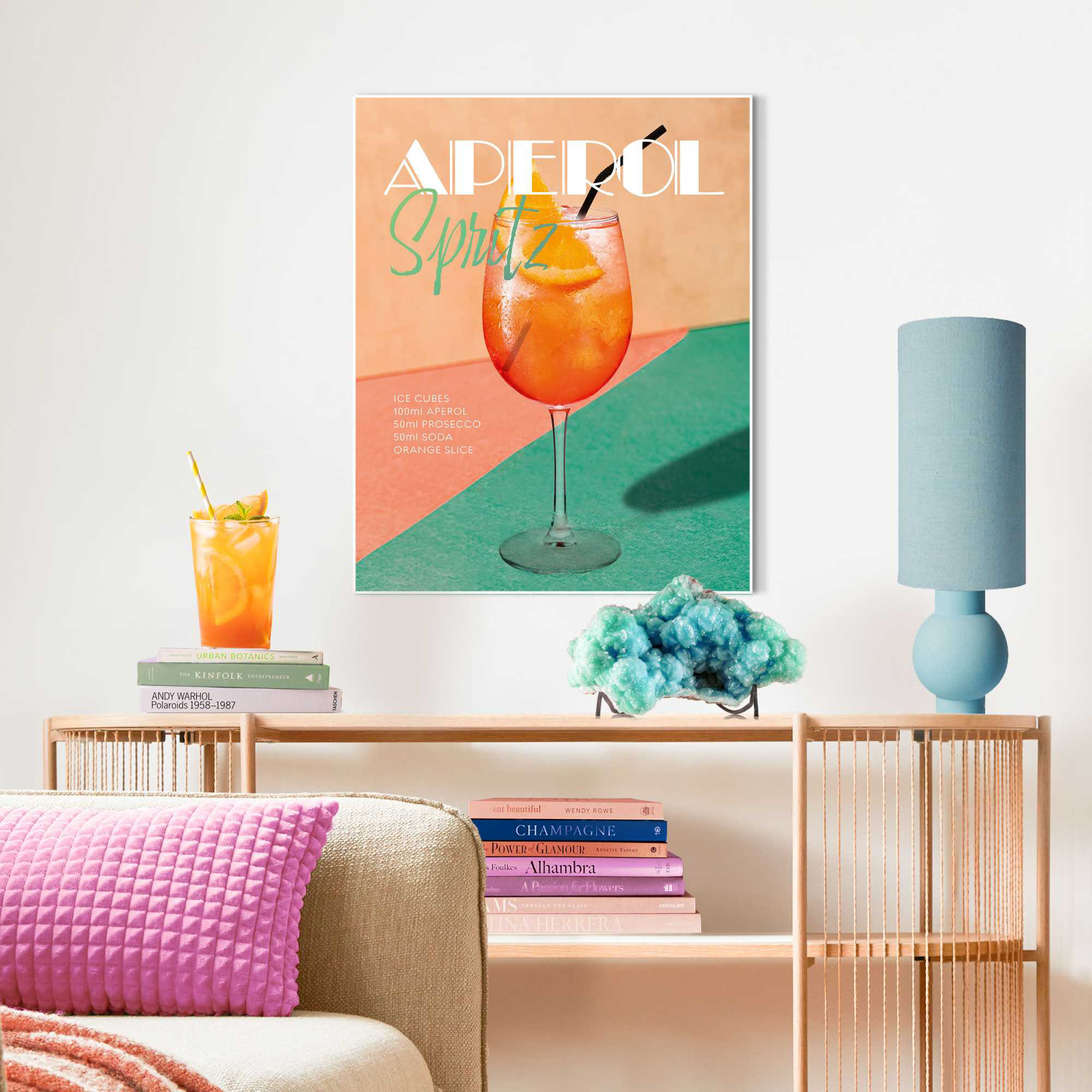Das Wandbild „Aperol Time“ in Orange, 40 × 50 cm, hängt in einem eingerichteten Wohnraum und zeigt die Größenwirkung an der Wand.