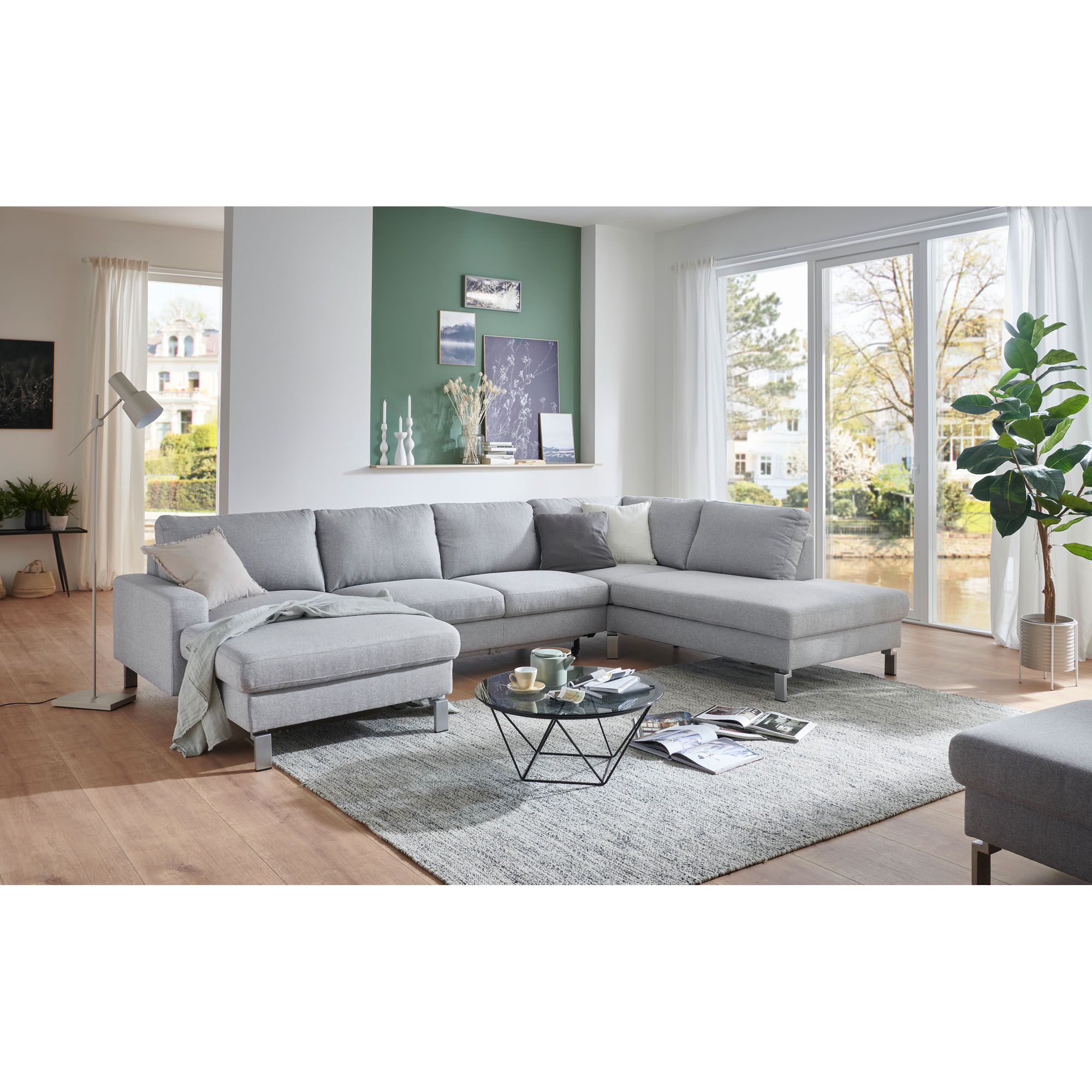 Großes Ecksofa mit zwei Ottomane in moderner Wohnraumsituation mit Teppich und Couchtisch