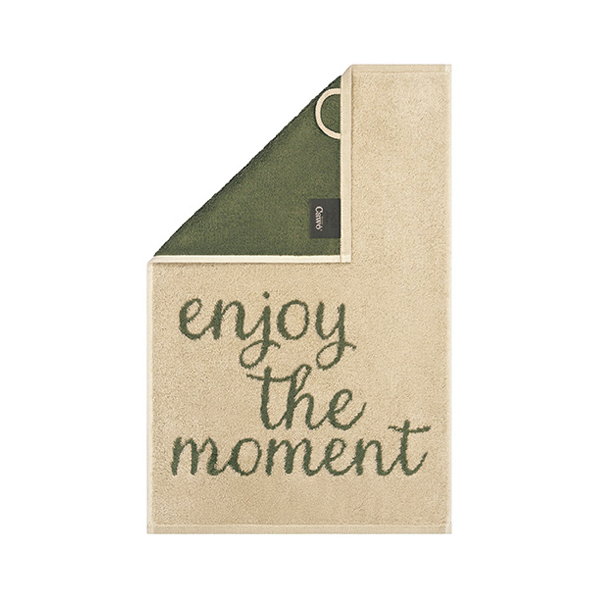 Beiges Gästetuch Postcard Towels mit dunkelgrünem Schriftzug „enjoy the moment“ und olivgrüner umgeschlagener Ecke.