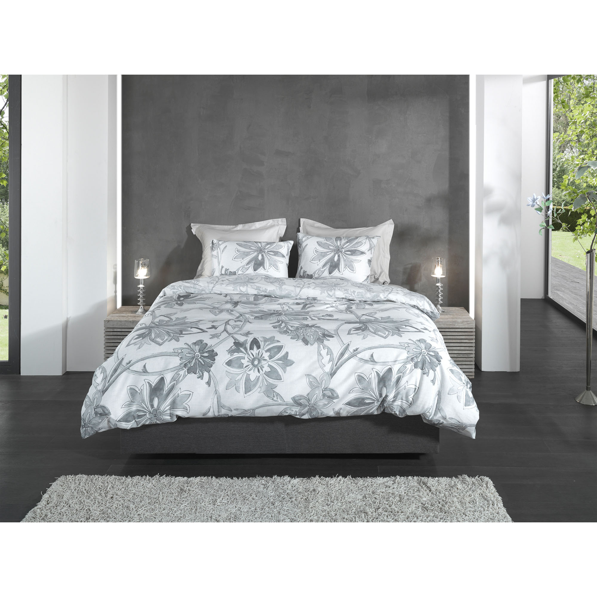 Bettwäsche Neva in Grey, 155 x 220 cm: bezogenes Bett in frontaler Schlafzimmerszene mit großen grauen Blumen- und Blättermotiven.